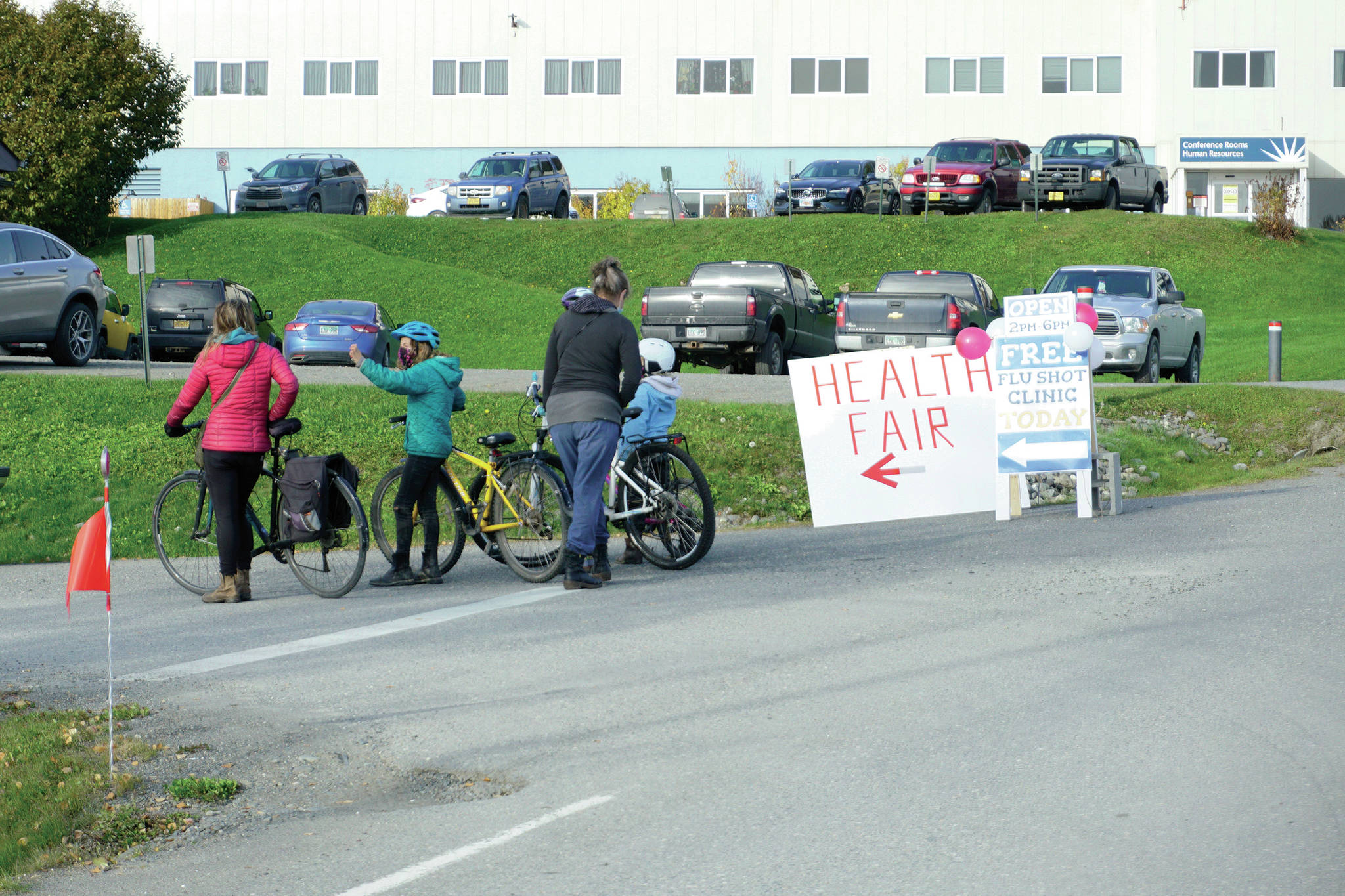 A group of women and children on bikes wait their turn to get flu shots at a clinic held last Friday, Oct. 16, 2020, at the South Peninsula Family Care Clinic in Homer, Alaska. About 330 free flu shots were administed on Oct. 16 and 17 at the clinic. Another free flu clinic is 4-7 p.m. Tuesday, Oct. 27, at the Homer United Methodist Church, administered by SVT Health & Wellness as part of the Rotary Health Fair. (PHoto by Michael Armstrong/Homer News)