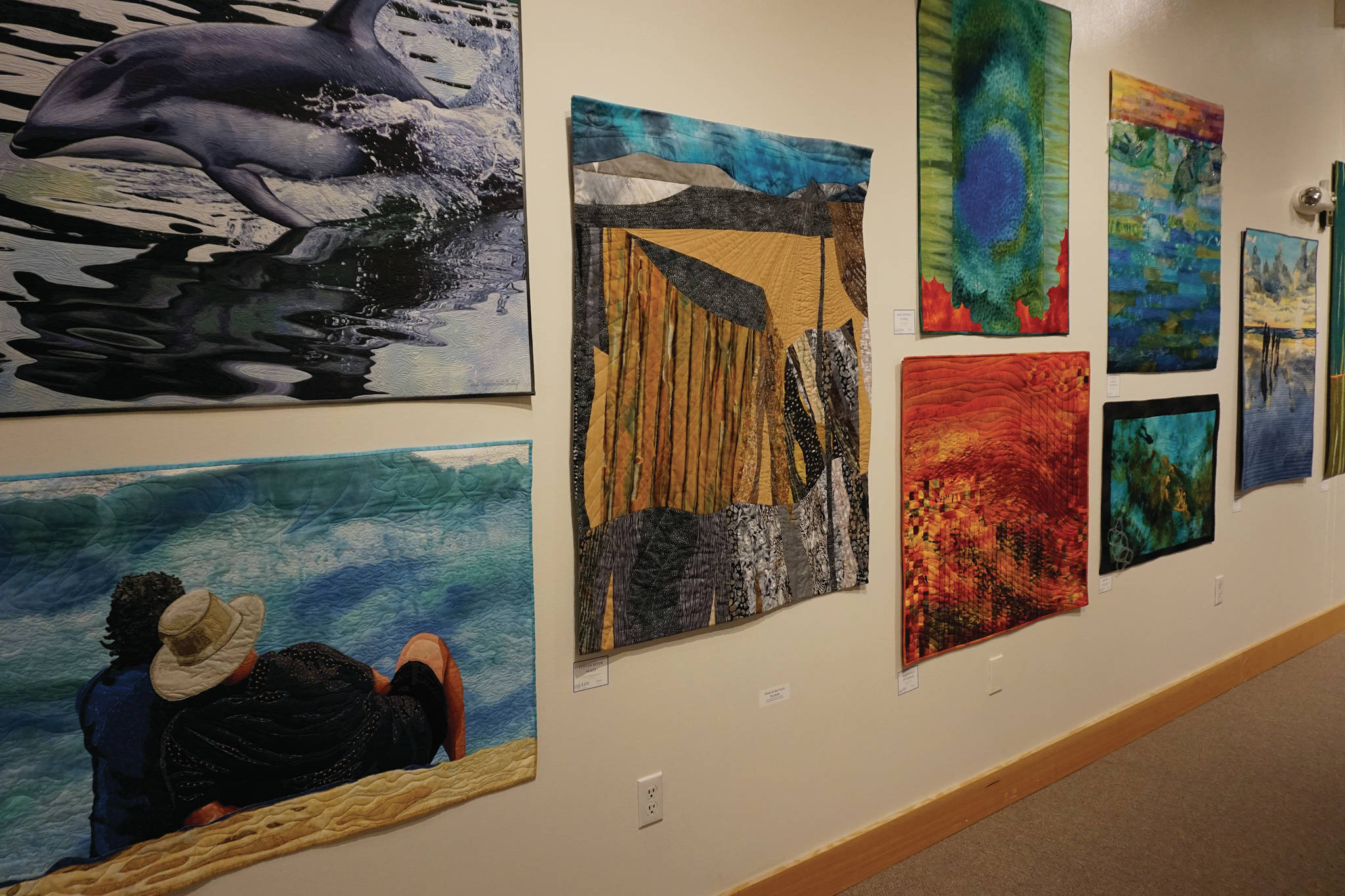 Some of the 45 art quilts featured in “Shifting Tides: Cloth in Convergence,” on exhibit from Oct. 9 to Nov. 28, 2020, at the Pratt Museum in Homer, Alaska. (Photo by Michael Armstrong/Homer News)