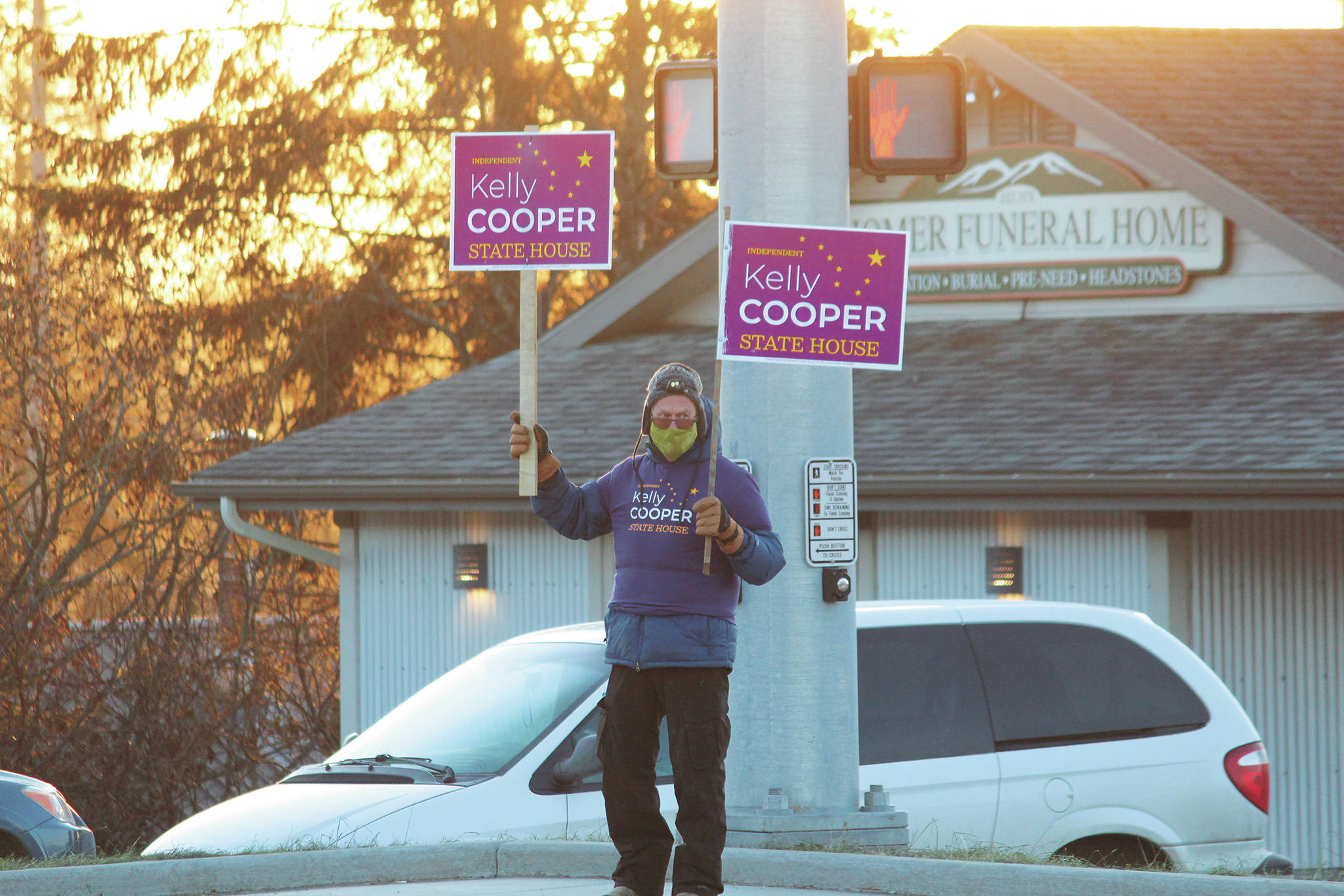 A supporter holds signs for Alaska House of Representatives District 31 candidate Kelly Cooper at the corner of Main Street and the Sterling Highway on Tuesday, Nov. 3, 2020 in Homer, Alaska. (Photo by Megan Pacer/Homer News)
