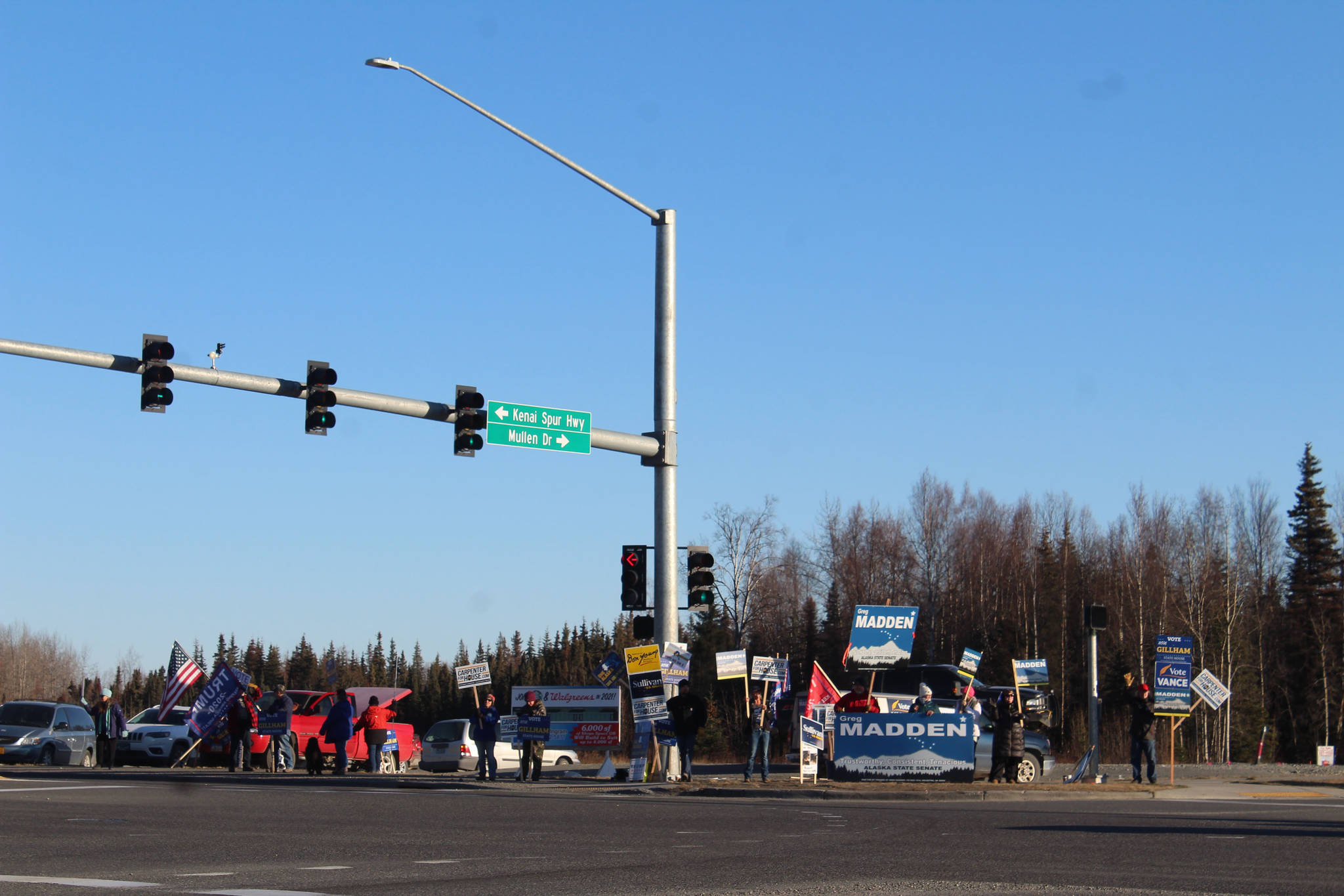 Supporters hold campaign signs at the intersection of Sterling Highway and Kenai Spur Highway on Tuesday, Nov. 3 in Soldotna, Alaska. (Photo by Ashlyn O’Hara/Peninsula Clarion)