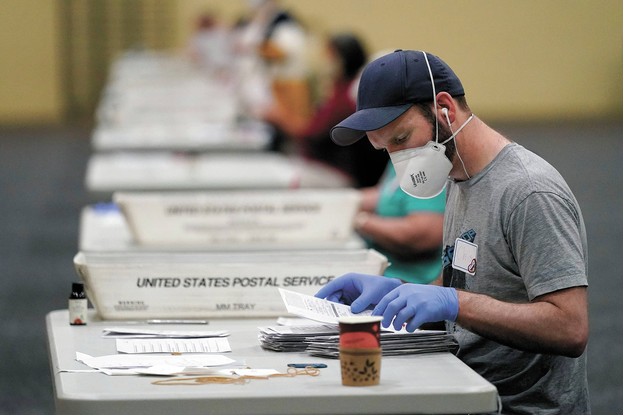 Workers prepare mail-in ballots for counting, Wednesday, Nov. 4, 2020, at the convention center in Lancaster, Pa., following Tuesday’s election. (AP Photo/Julio Cortez)