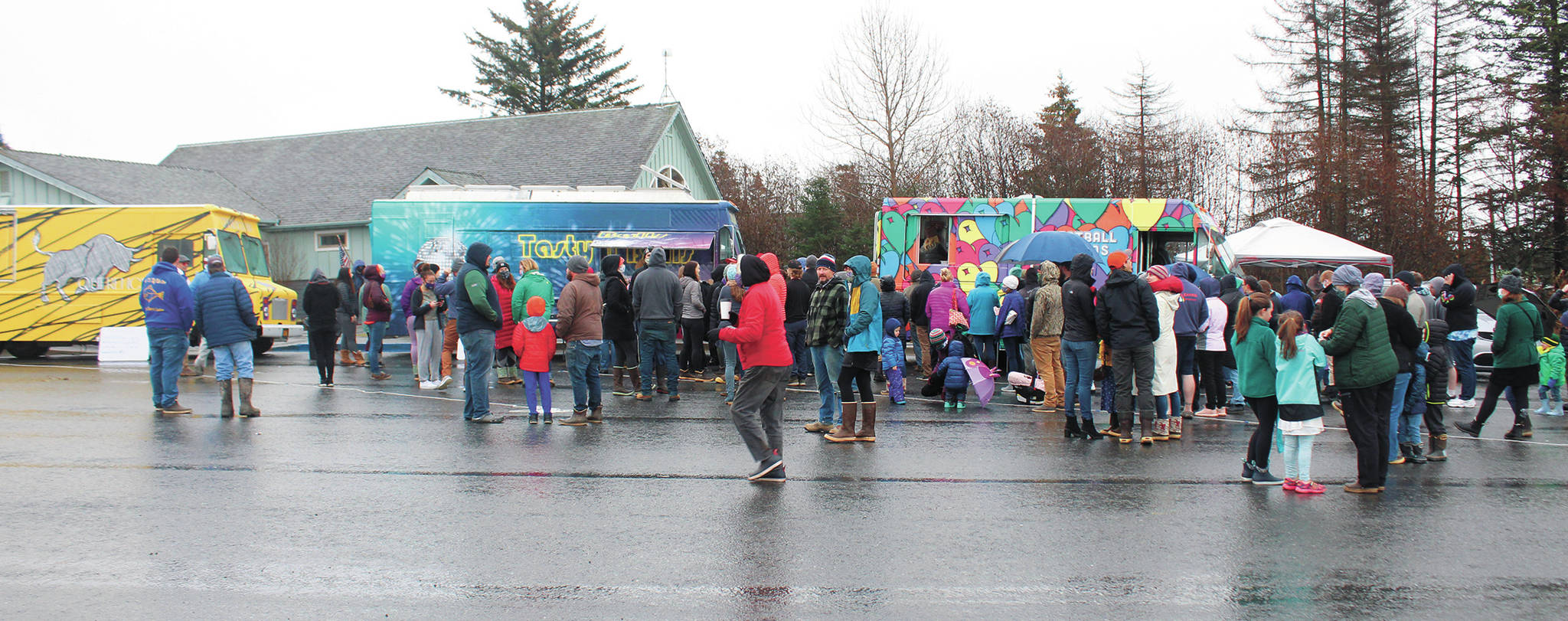 People wait in line to eat from three different visiting food trucks on Sunday, Nov. 8 at the Homer Chamber of Commerce & Visitor Center in Homer. Five food trucks came to town as part of the Food Network show “The Great Food Truck Race.” (Photo by Megan Pacer/Homer News)