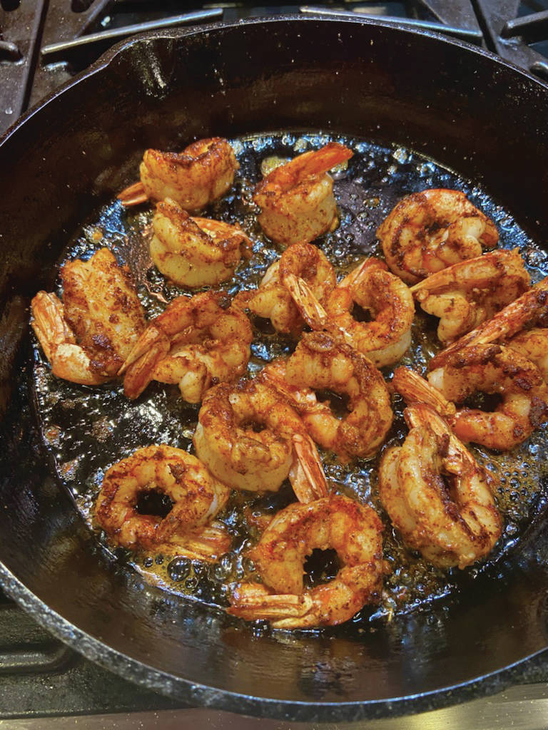 The recipe for warm chili shrimp salad with little gems and tomatoes starts with cooking the shrimp until golden brown, as seen here on Tuesday, Dec. 22, 2020, in the kitchen of her Homer, Alaska, home. (Photo by Teri Robl)