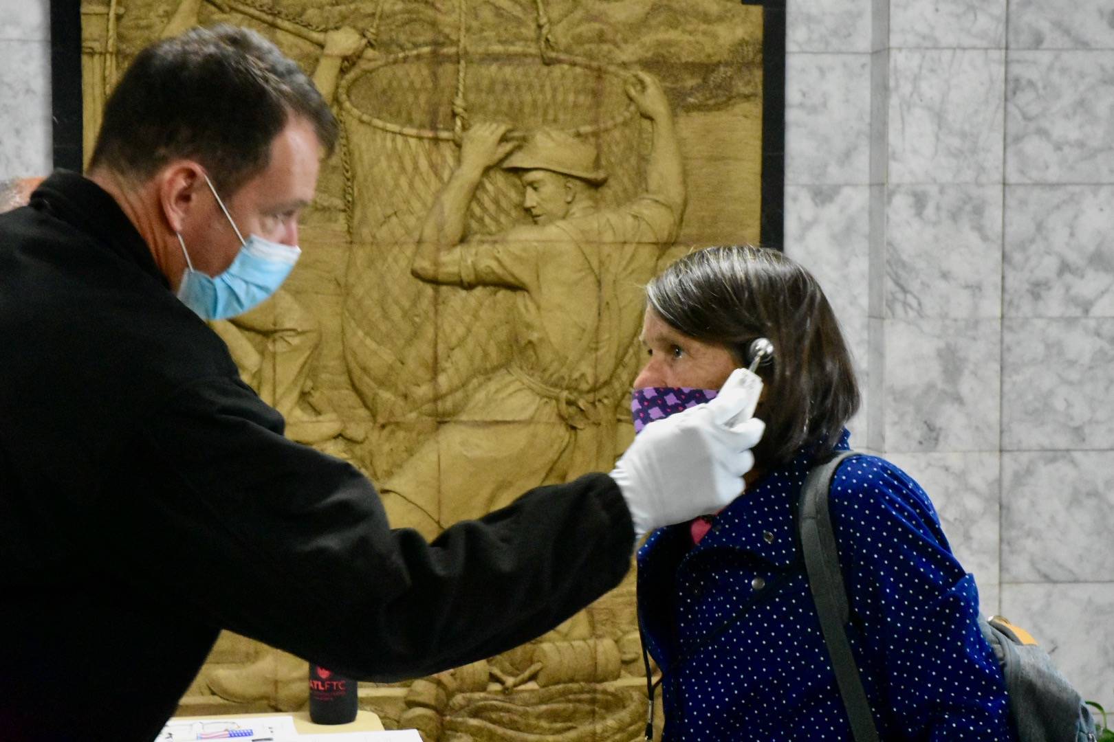 Peter Segall / Juneau Empire File
Rep. Jennifer Johnston, R-Anchorage, gets her temperature taken as she enters the Alaska State Capitol on Monday, May 18, 2020. New policies will require all staff and legislators to wear masks in chambers.