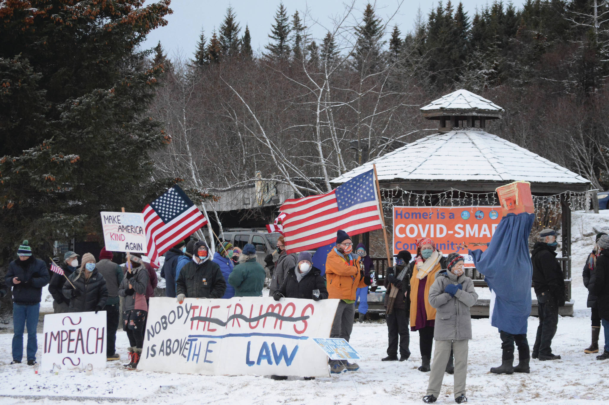 About 50 people protest the Jan. 6, 2021, riot at the U.S. Capitol on Saturday, Jan. 9, 2021, at WKFL Park in Homer, Alaska. The group reacted to the events in which rioters broke into the U.S. Capitol while Congress attempted to tally the Electoral College results in which former Vice President Joe Biden won the presidential election. Charles Aguilar, far right, wore a Trump puppet costume. (Photo by Michael Armstrong/Homer News)