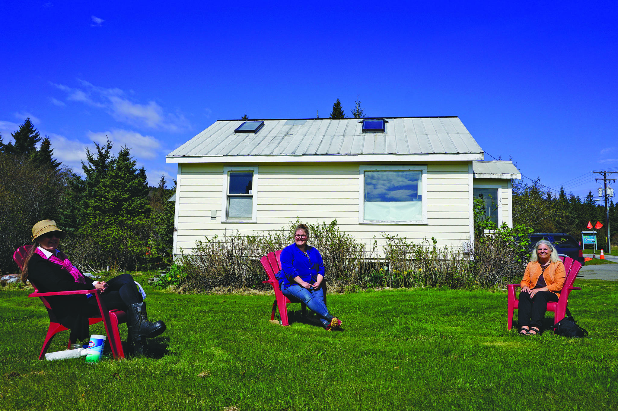 Pratt Museum officials pose for a photograph while practicing social distancing on the museum lawn on Friday, May 15, 2020, in Homer, Alaska. From left to right are Jennifer Gibbins, executive director; Savanna Bradley, curator, and Marilyn Sigman, naturalist in residence. (Photo by Michael Armstrong/Homer News)