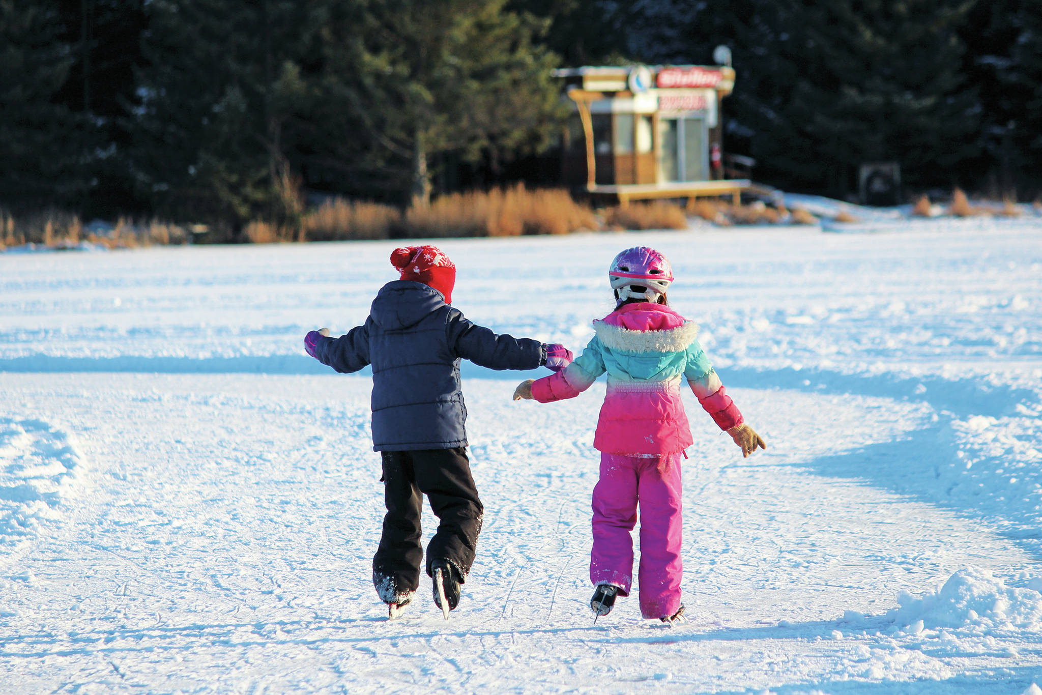 Two children skate around an ice ribbon on Beluga Lake during the Skate the Lake event Saturday, Feb. 6, 2021 in Homer, Alaska. The Homer Hockey Association, which hosted the event, plowed a large skating area as well as several skating ribbons and paths along the lake. (Photo by Megan Pacer/Homer News)