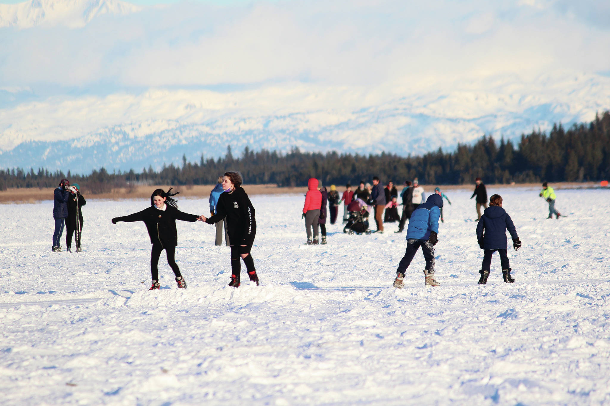 Friends and families skate along several paths plowed onto Beluga Lake for the Skate the Lake event Saturday, Feb. 6, 2021 in Homer, Alaska. It was hosted for the community by the Homer Hockey Association. (Photo by Megan Pacer/Homer News)