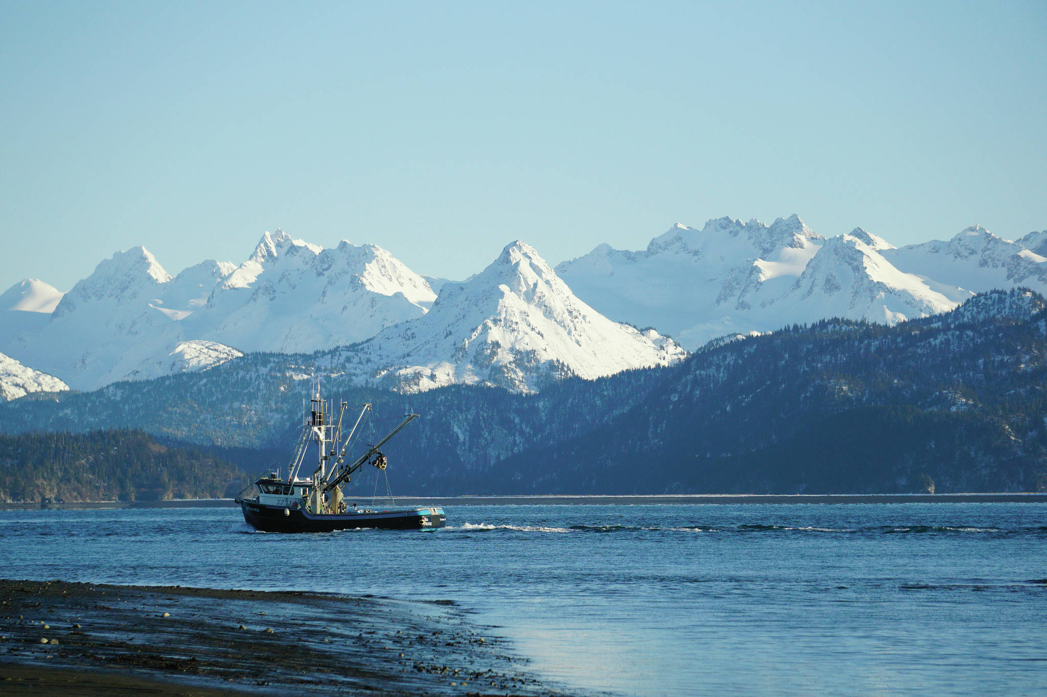 A fishing boat passes in front of Poot Peak on Sunday, Feb. 7, 2021, in Homer, Alaska. (Photo by Michael Armstrong/Homer News)