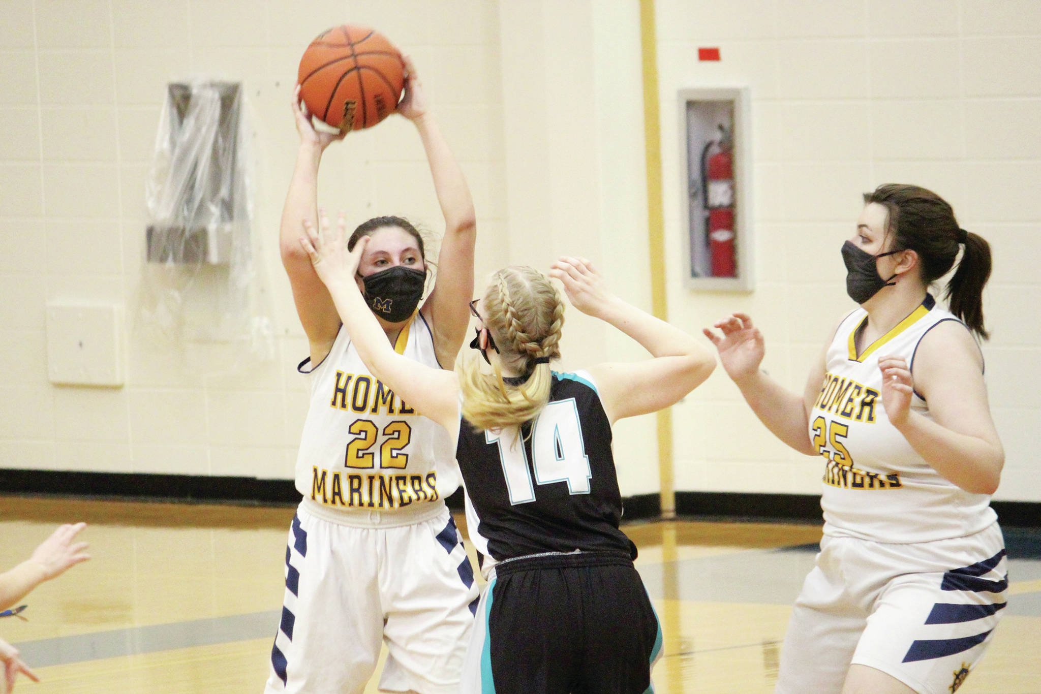 Homer’s Hannah Hatfield looks for a teammate to pass to under pressure from Nikiski’s Avery White during a Thursday, Feb. 11, 2021 basketball game at the Alice Witte Gymnasium in Homer, Alaska. (Photo by Megan Pacer/Homer News)