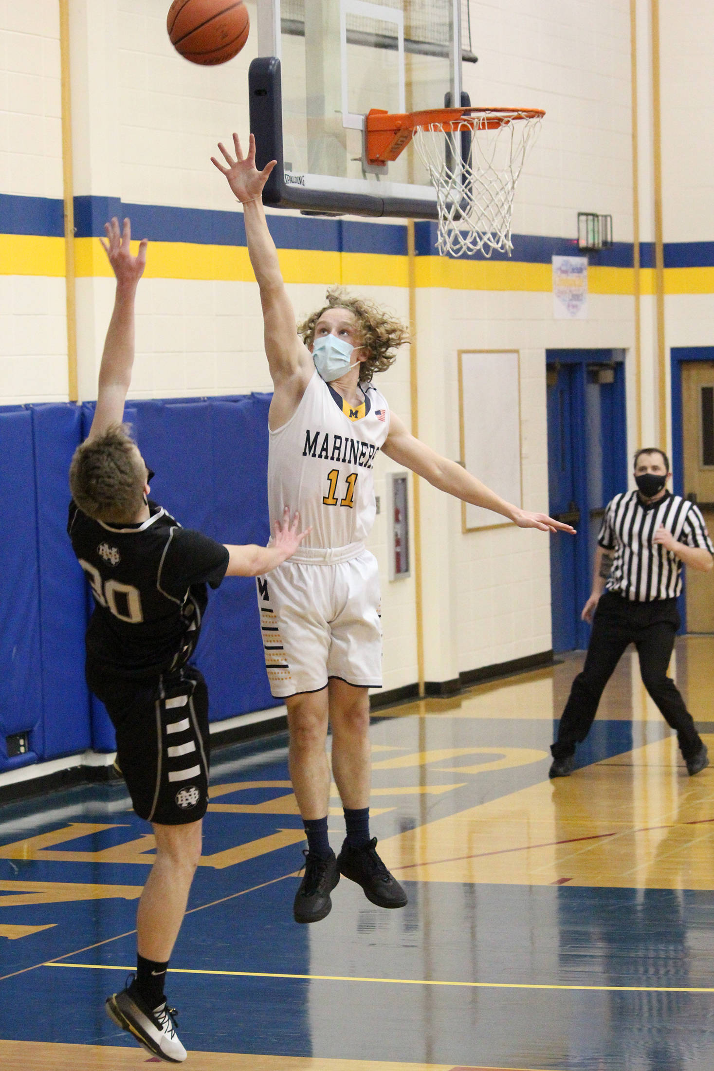 Homer’s Parker Lowney tries to block a shot from Nikiski’s Austin Stafford during a Thursday, Feb. 11, 2021 basketball game at the Alice Witte Gymnasium in Homer, Alaska. (Photo by Megan Pacer/Homer News)
