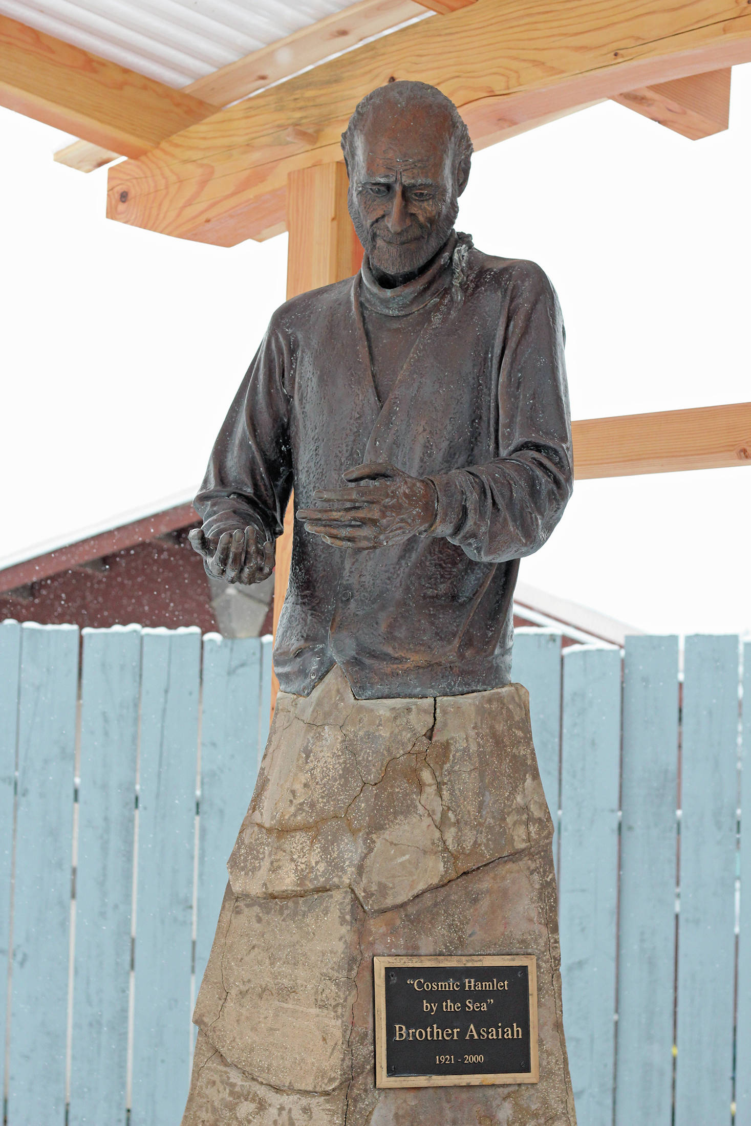 A statue of Brother Asaiah rests under a protective wooden structure on Thursday, Feb. 18, 2021 outside KBBI Public Radio in Homer, Alaska. (Photo by Megan Pacer/Homer News)