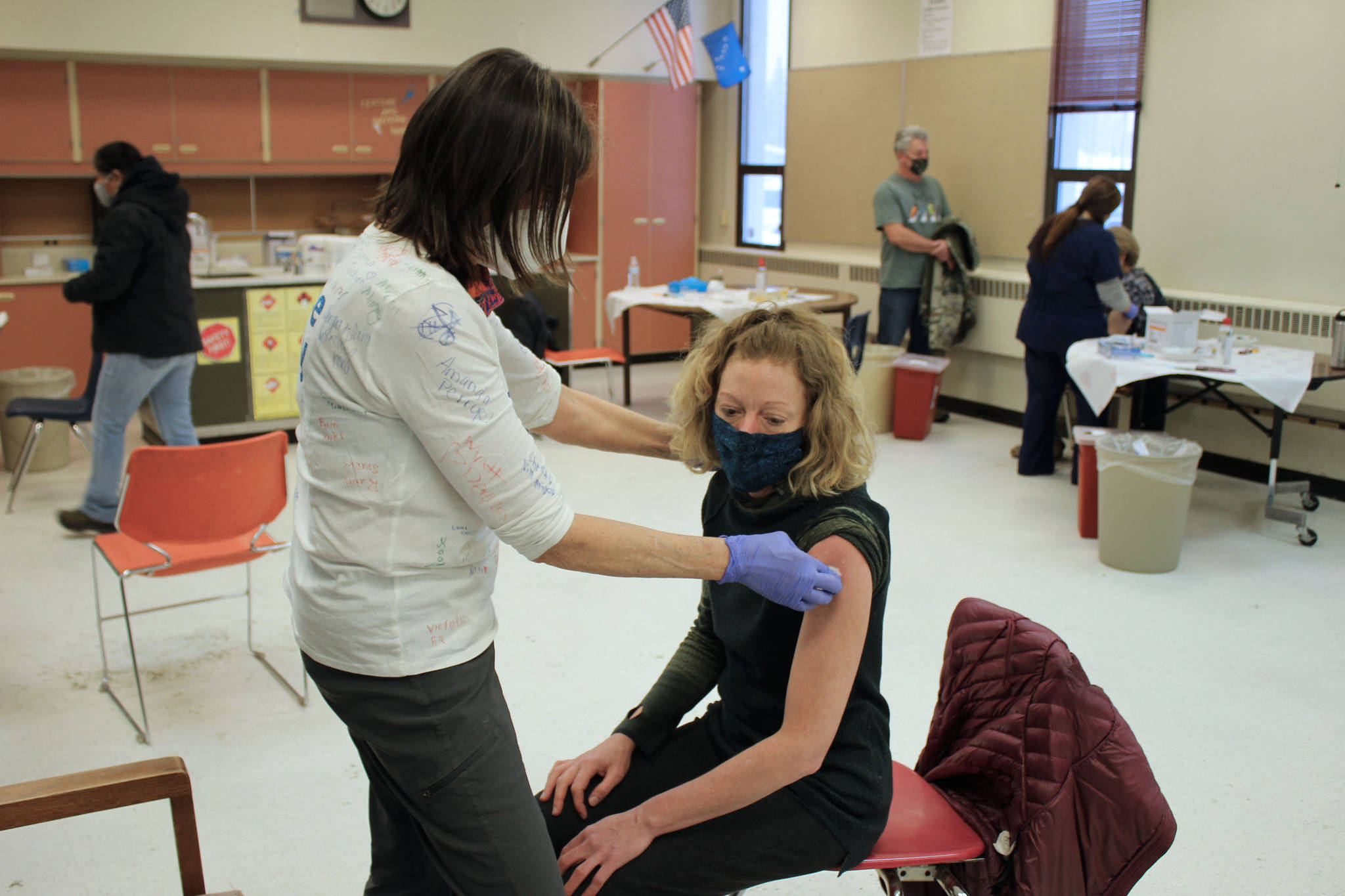 Tracy Silta (left) administers a dose of a COVID-19 vaccine to Melissa Linton during a vaccine clinic at Soldotna Prep School on Friday, Feb. 26, 2021 in Soldotna, Alaska. (Photo by Ashlyn O’Hara/Peninsula Clarion)