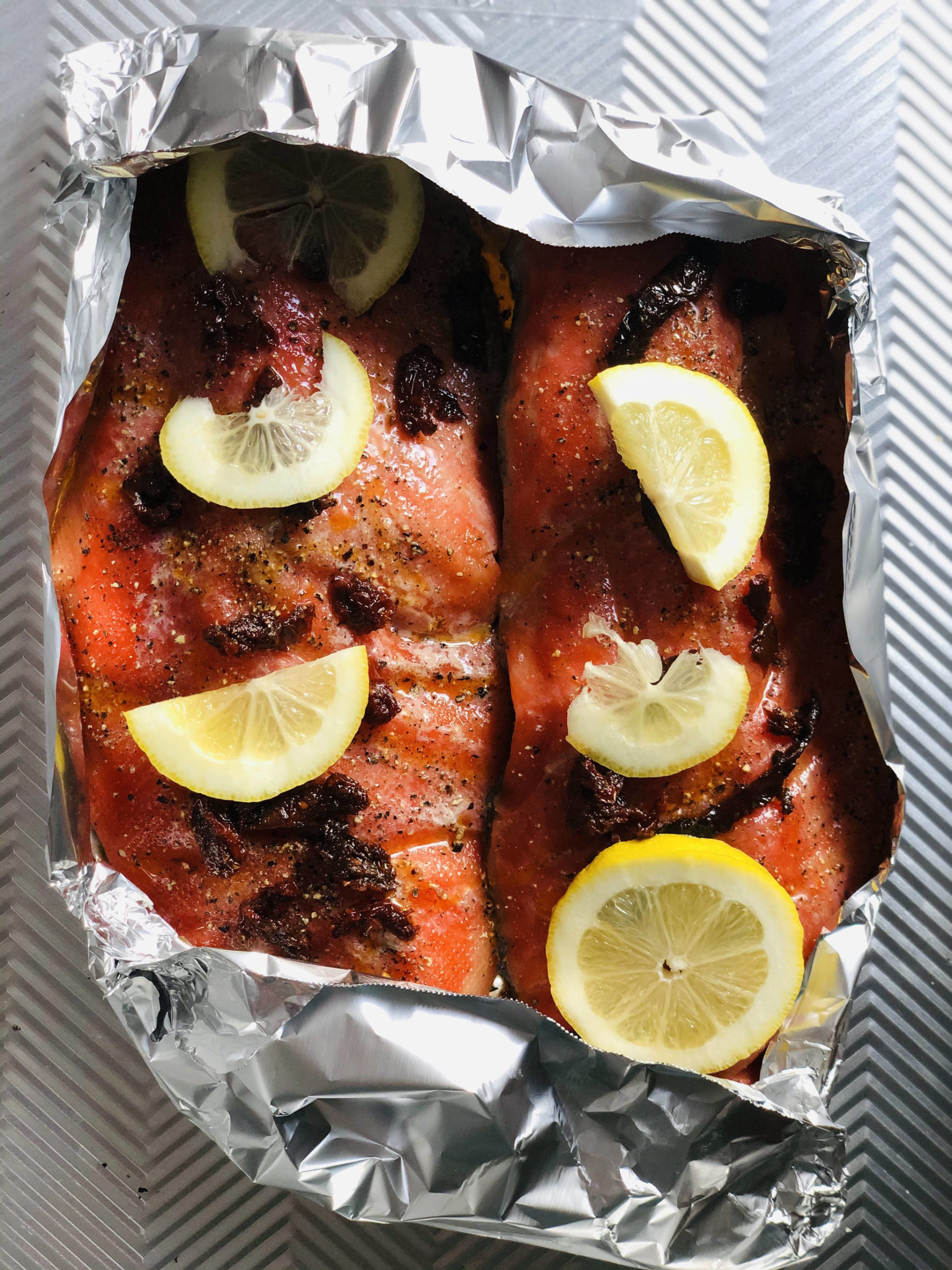 Victoria Petersen/Peninsula Clarion
Salmon dressed up with sun-dried tomatoes and lemons is ready to go in the oven.