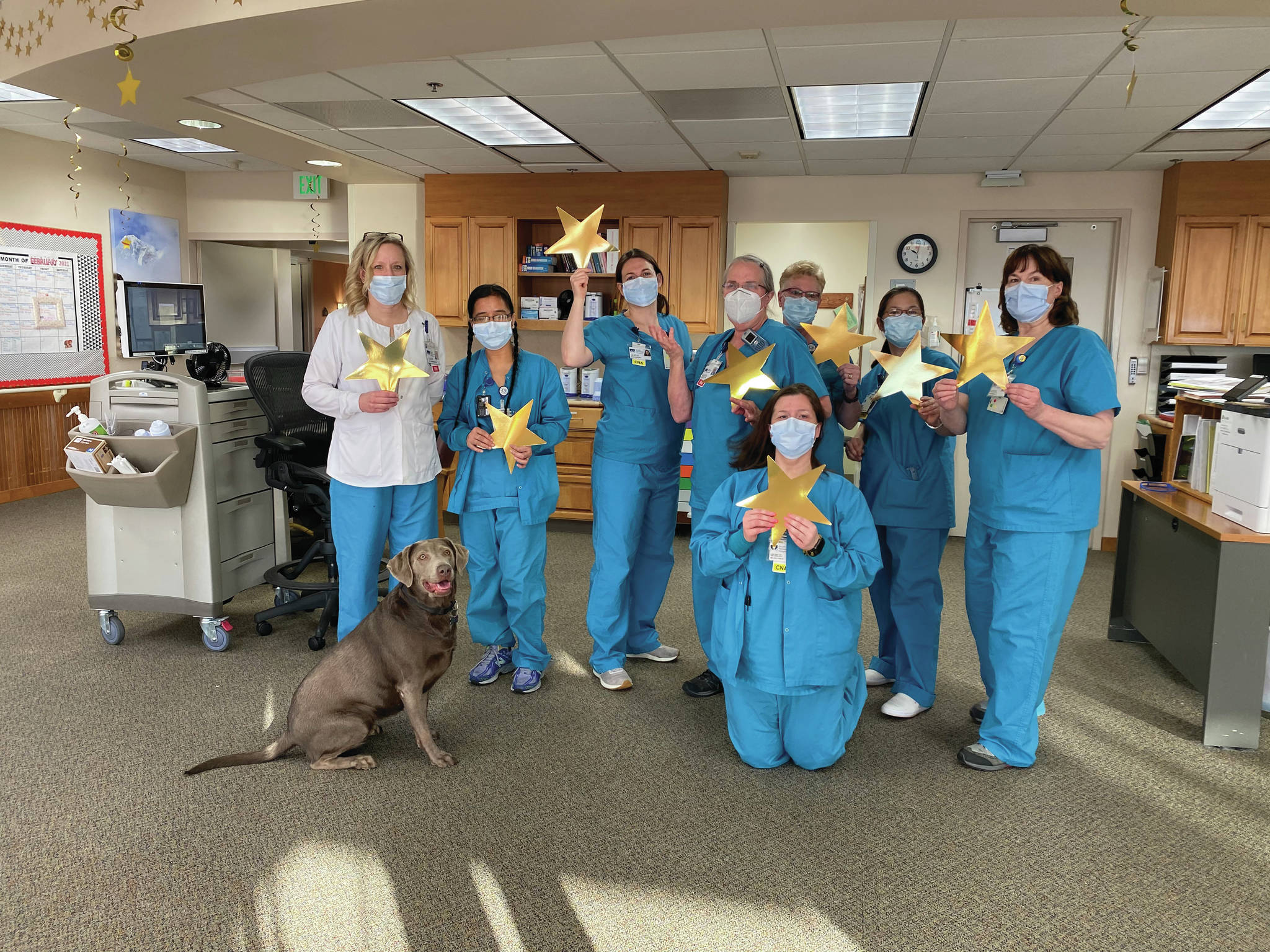 Long Term Care staff celebrate receiving the five-star rating from the Centers for Medicare & Medicaid Services on Feb. 19, 2021, at South Peninsula Hospital in Homer, Alaska. From left to right are Cathy Myers, Director of Nursing; Bella the dog, Nanet Minke, Certified Nursing Assistant; Nicole McKinney,CNA; Bonnie Betley, Registered Nurse; Susan Hubbard, CNA, Ana Jones, CNA; Leone Morra RN; and Melissa Dunkle CNA, in the front kneeling. (Photo courtesy South Peninsula Hospital)