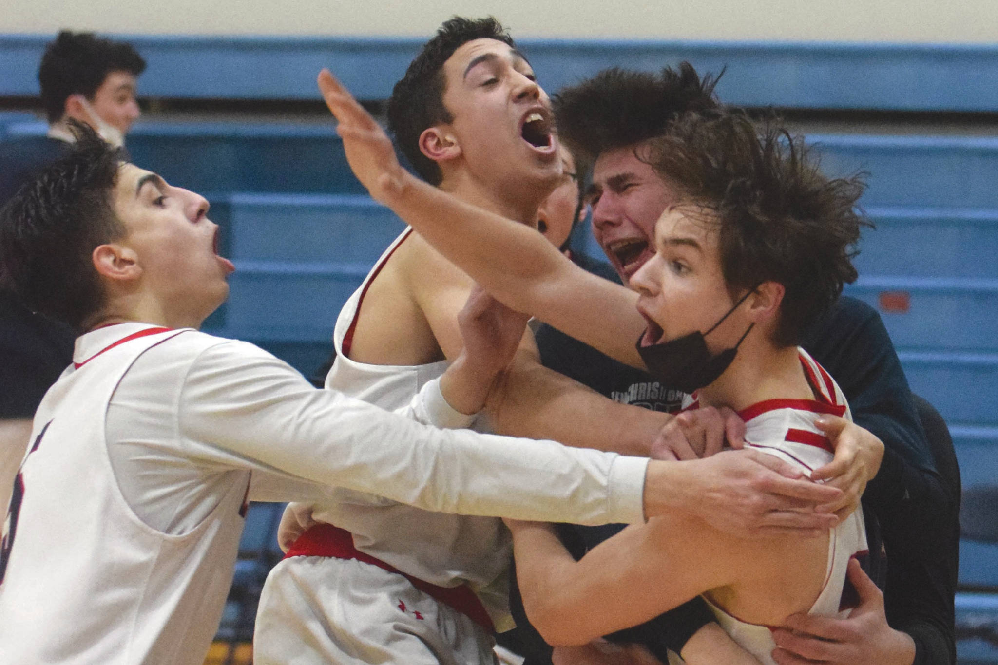 Lumen Christi's Brenden Gregory is mobbed by teammates after hitting the game-winning 3-pointer in the Peninsula Conference championship game against Ninilchik on Friday, March 19, 2021, at Soldotna High School in Soldotna, Alaska. (Photo by Jeff Helminiak/Peninsula Clarion)