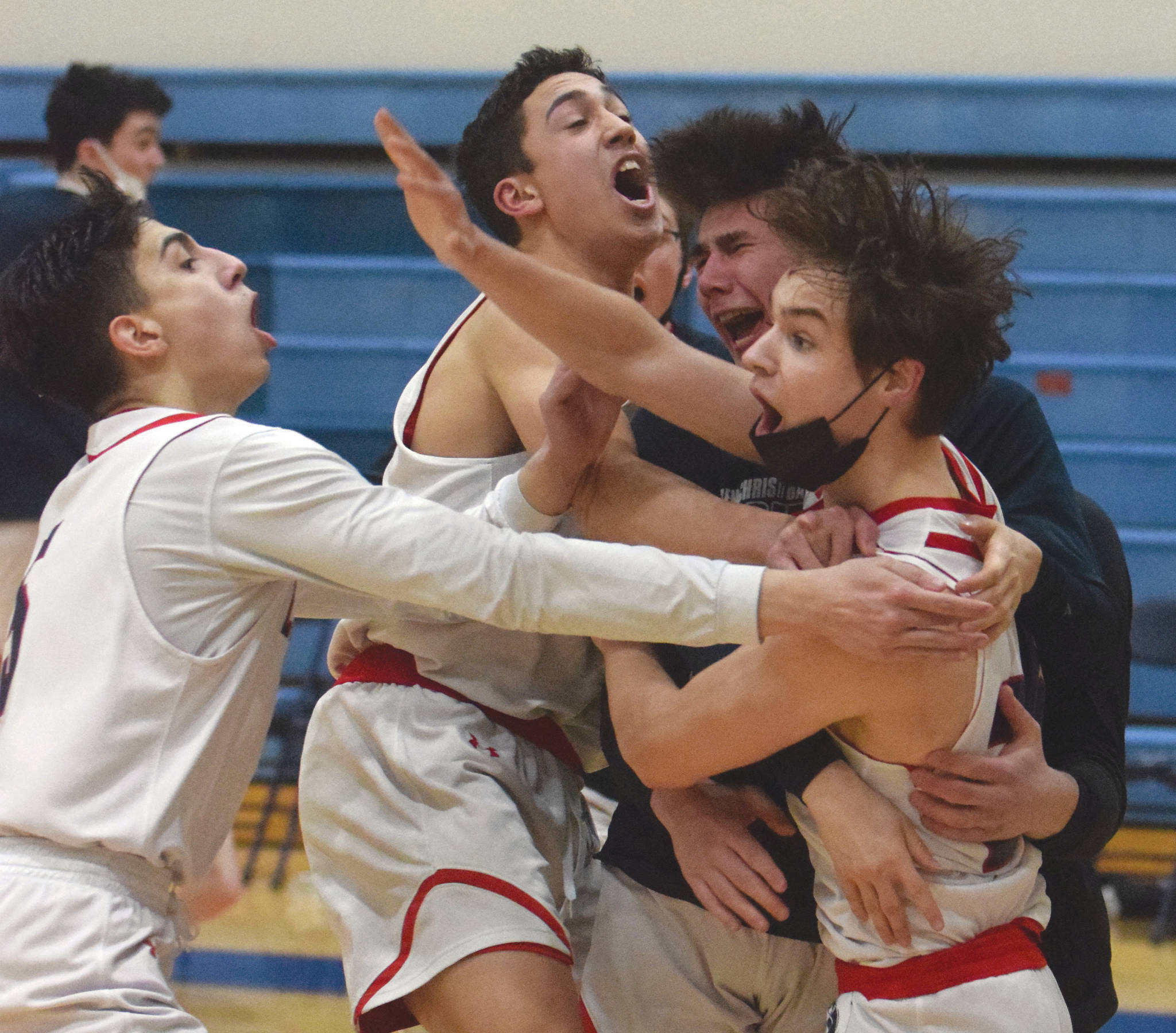 Lumen Christi’s Brenden Gregory is mobbed by teammates after hitting the game-winning 3-pointer in the Peninsula Conference championship game against Ninilchik on Friday, March 19, 2021, at Soldotna High School in Soldotna, Alaska. (Photo by Jeff Helminiak/Peninsula Clarion)
