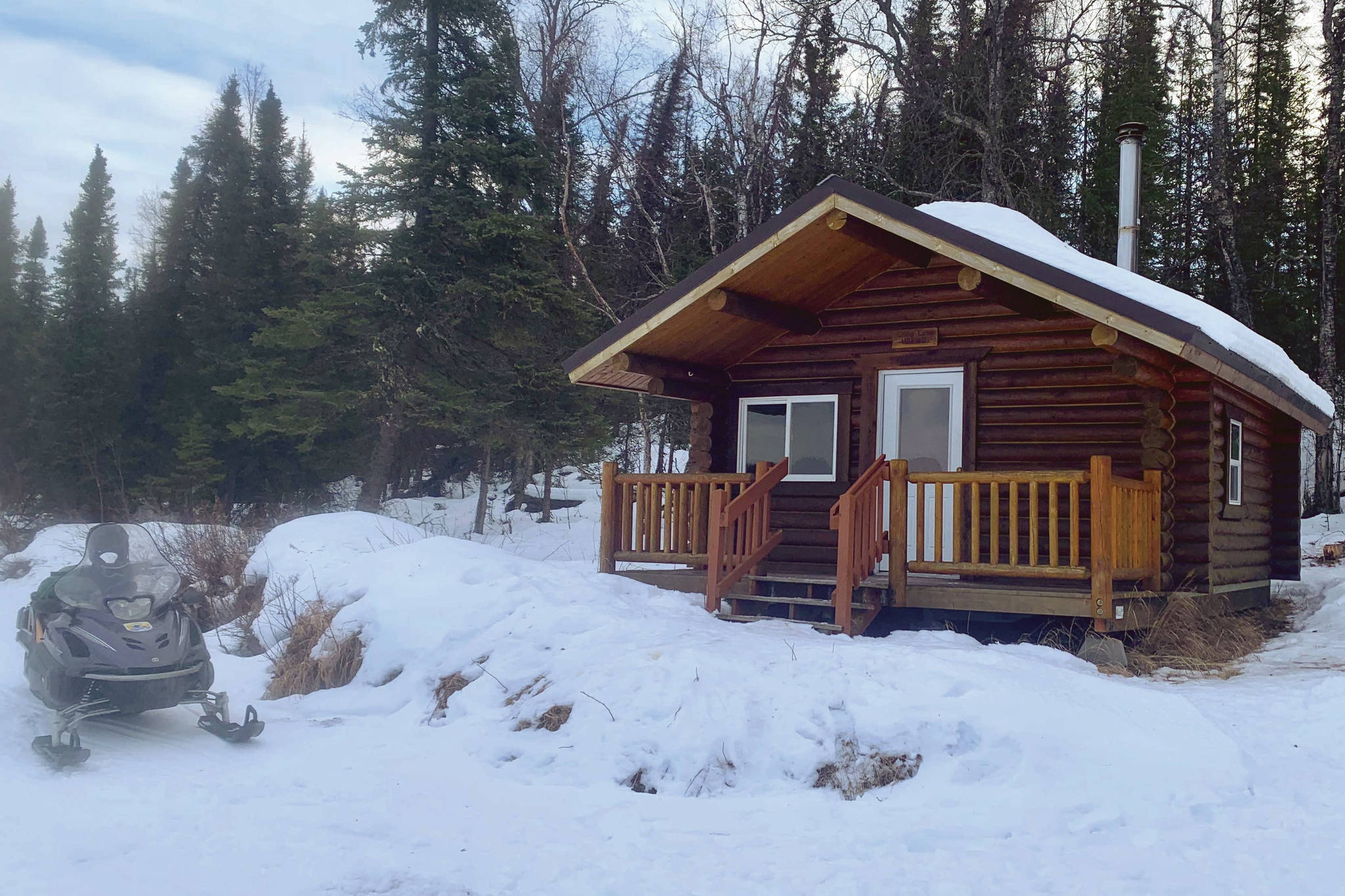 A snowmachine at rest in front of the Snag Lake public use cabin. (Photo provided by USFWS)