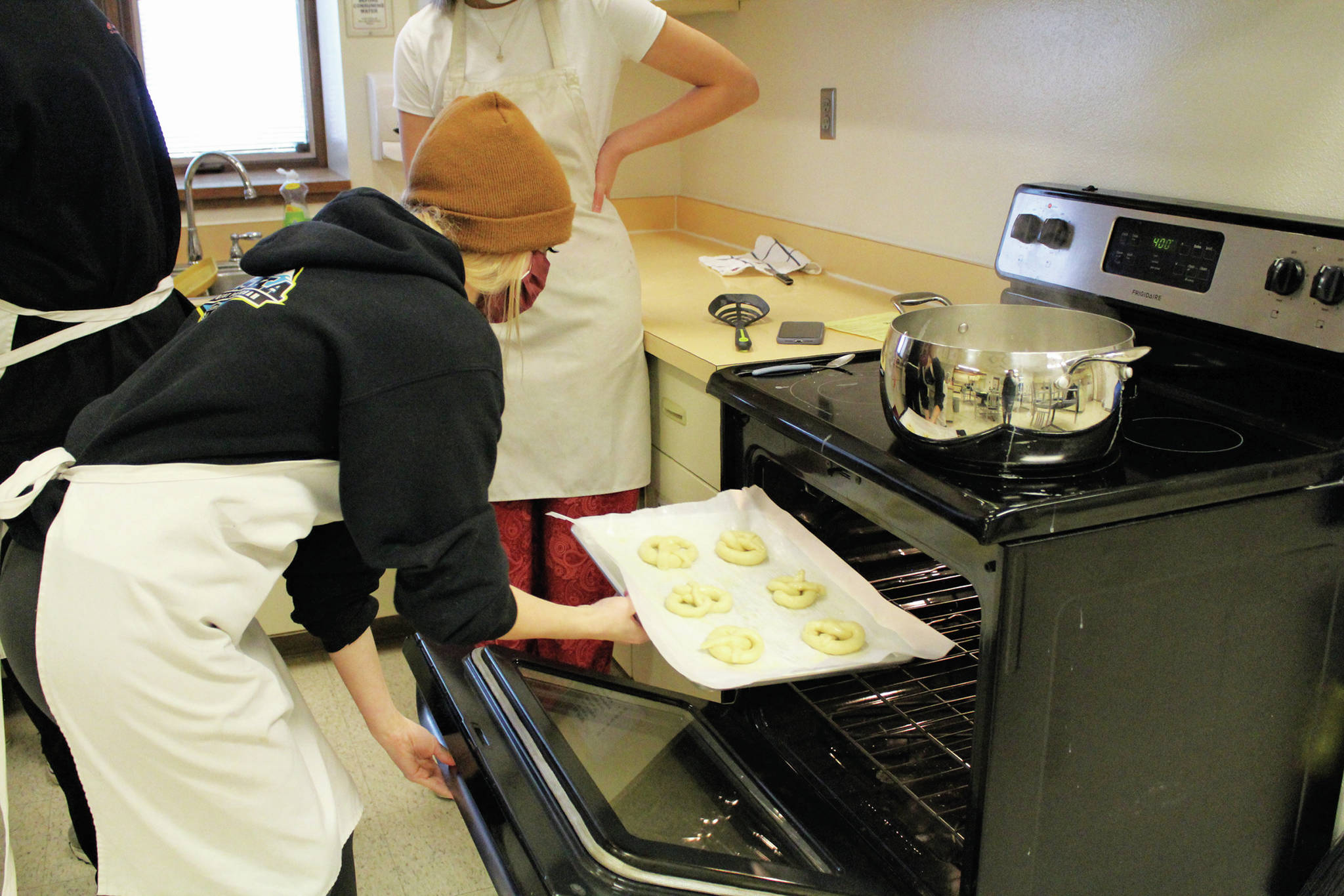 Izzy Dye pops a batch of pretzels into the oven during a high school food and nutrition class at Homer High School in Homer, Alaska. (Photo by Katelyn Engebretsen/Homer High Yearbook)