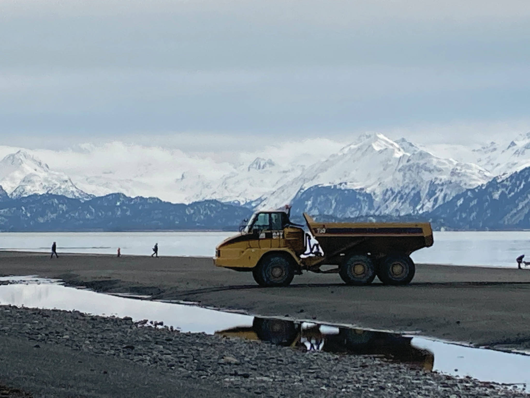 Workers with Psenak Construction return with an empty load after dumping armor rock at the Ocean Drive seawall on Monday, March 22, 2021, at Mariner Park on the Homer Spit in Homer, Alaska. (Photo by Michael Armstrong/Homer News)