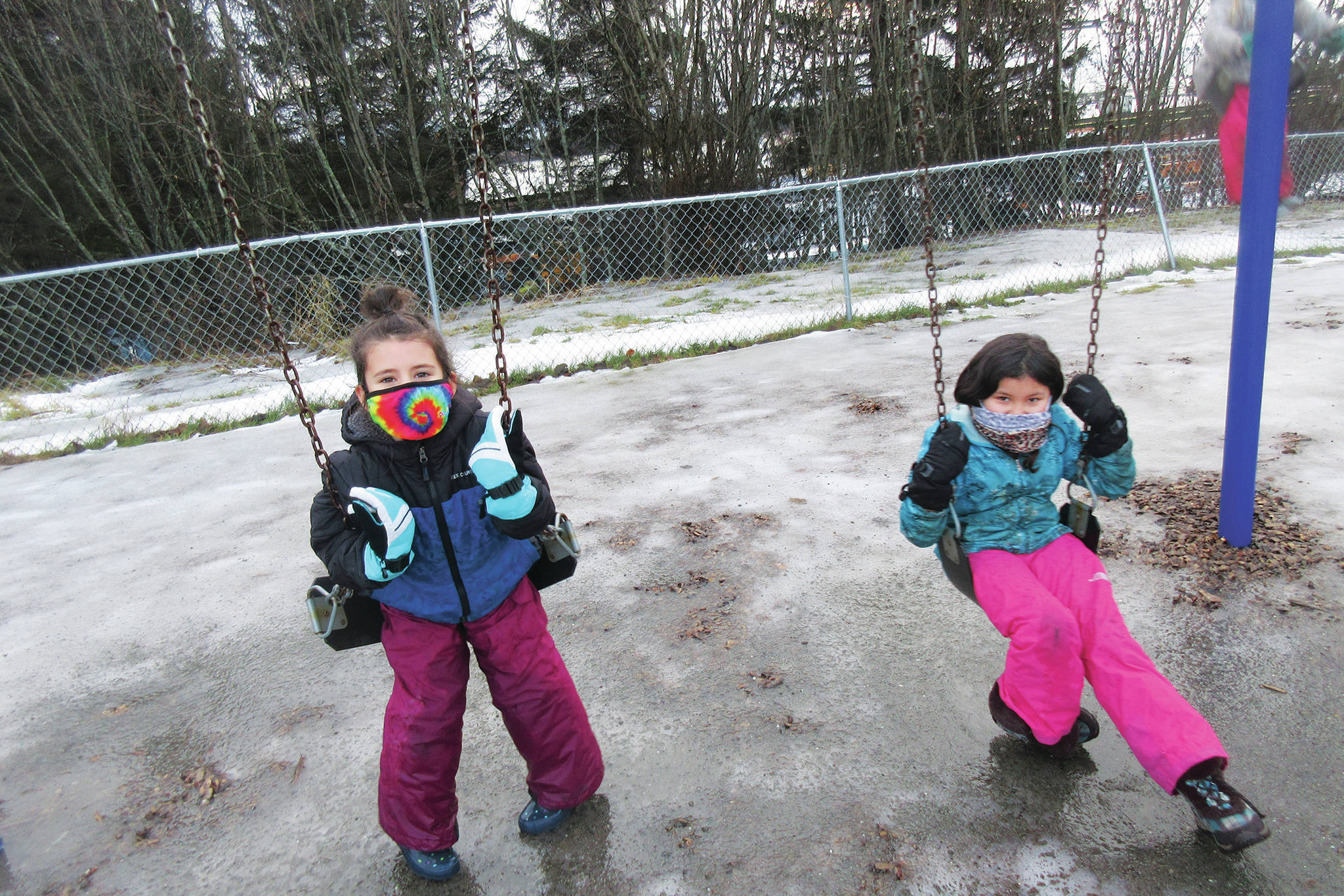 Students Sabriel Davidson and Kenadi Smith play on the swings on Monday, Jan. 11, 2021 at Fireweed Academy in Homer, Alaska. Elementary students were able to return to onsite schooling five days a week starting Monday. (Photo courtesy Todd Hindman/Fireweed Academy)