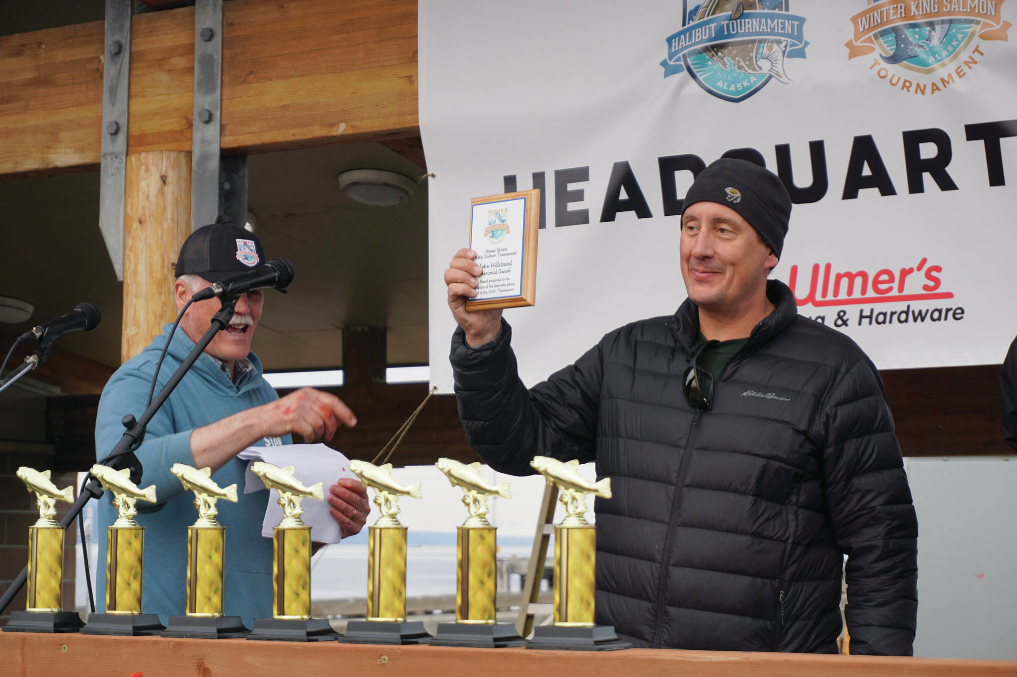 Capt. Jay Marley of the Fly Dough accepts the captain’s award for the boat that had the first-place fish in the 2021 Homer Winter King Salmon Tournament. Marley’s son, Andrew, caught the 25.62-pound winner. Homer Chamber of Commerce and Visitor Center Executive Director Brad Johnson, left, presented the plaque on Saturday, April 17, 2021, on the Homer Spit in Homer, Alaska. (Photo by Michael Armstrong/Homer News)