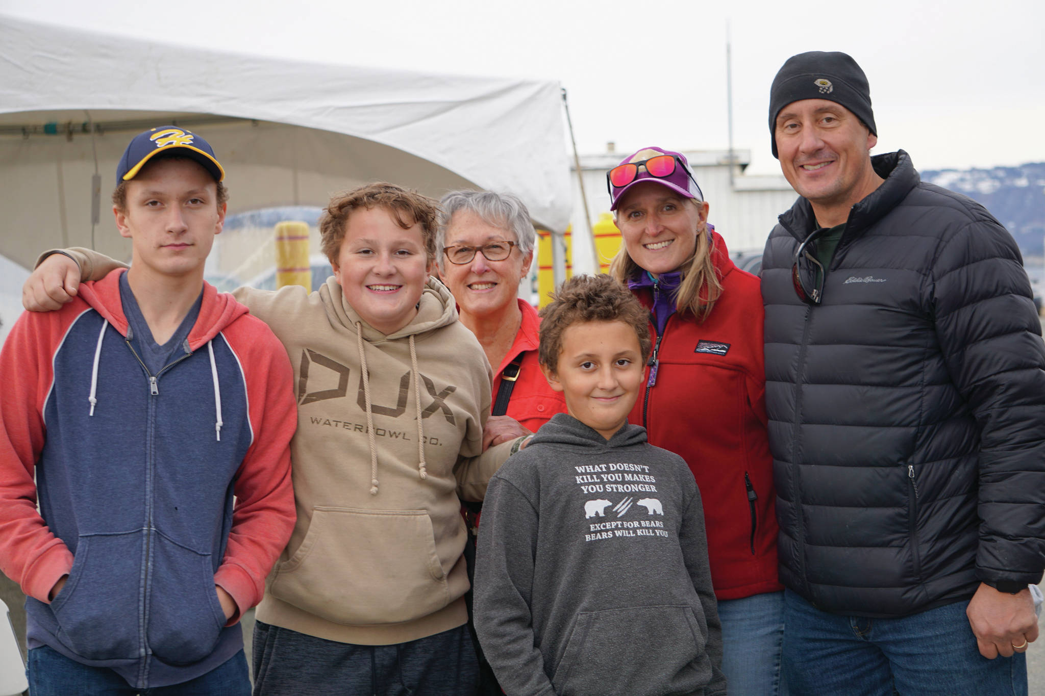 Andrew Marley, the 2021 Homer Winter King Salmon Tournament winner, fourth from left, poses with his family on Saturday, April 17, 2021, on the Homer Spit in Homer, Alaska. Andrew won the tournament with a 25.62-pound white king salmon fishing on the Fly Dough. From left to right are Zach Marley, Weston Marley, grandmother Susan Oesting, Andrew Marley, Erica Marley, and Capt. Jay Marley. (Photo by MIchael Armstrong/Homer News)