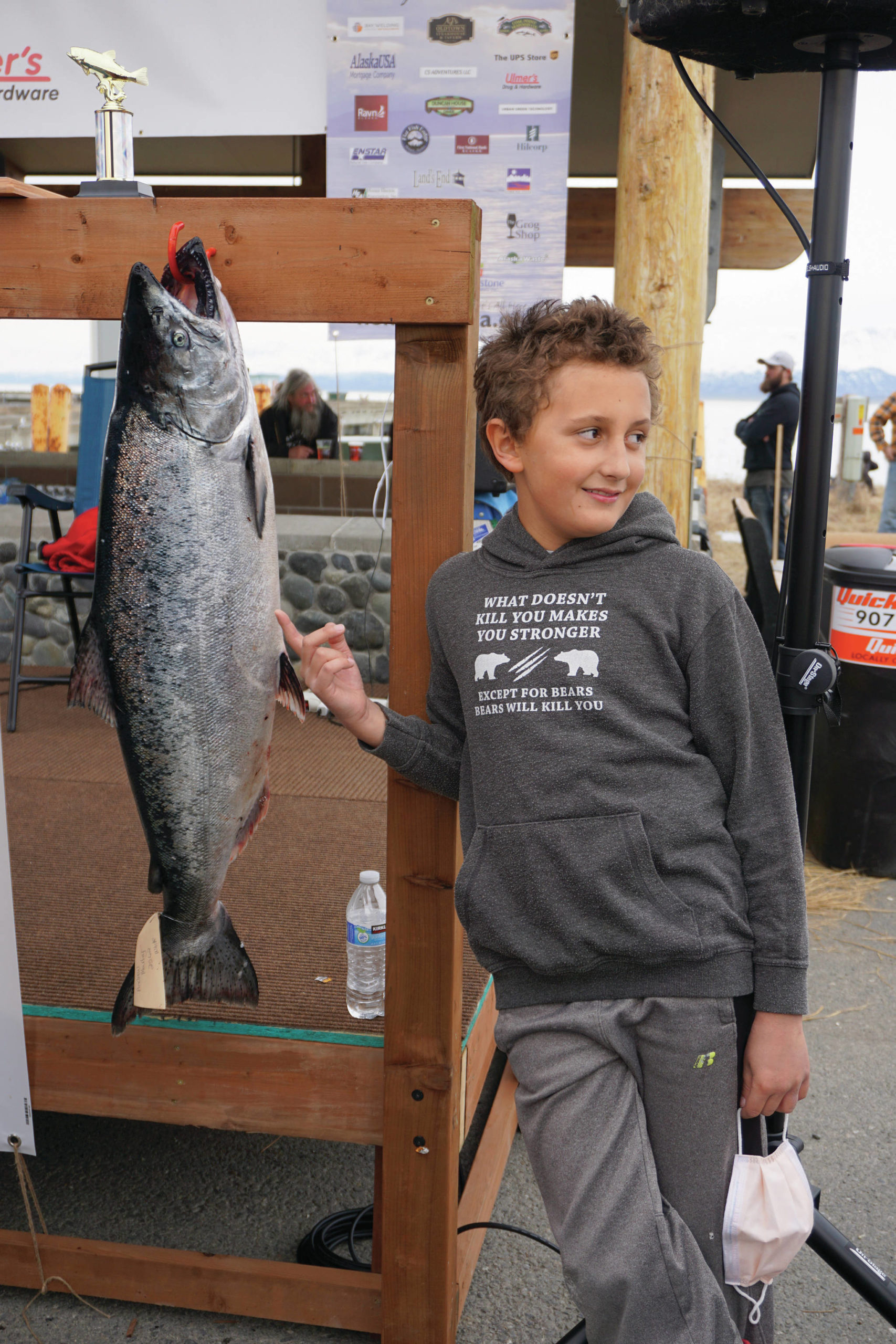 Andrew Marley, the 2021 Homer Winter King Salmon Tournament winner, points to his prize winning 25.62-pound white king salmon on Saturday, April 17, 2021, on the Homer Spit in Homer, Alaska. (Photo by Michael Armstrong/Homer News)
