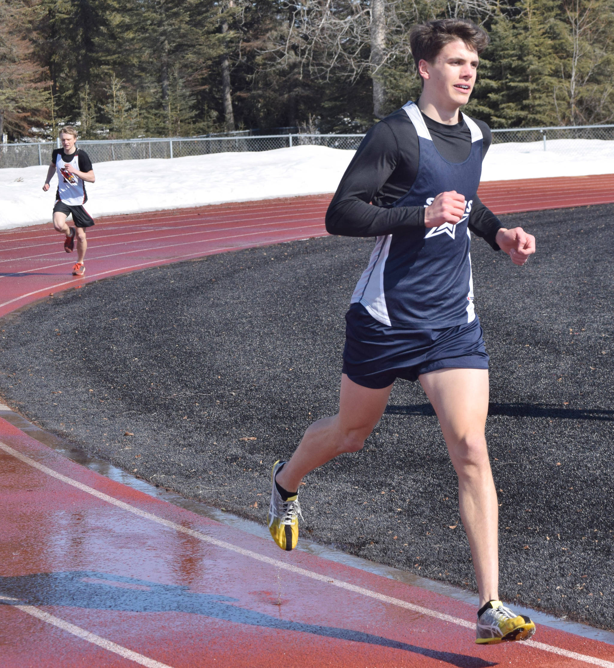 Soldotna’s Nathanael Johnson leads Kenai Central’s Jack Laker on the way to victory in the 1,600-meter run in a dual meet Friday, April 16, 2021, at Kenai Central High School in Kenai, Alaska. (Photo by Jeff Helminiak/Peninsula Clarion)