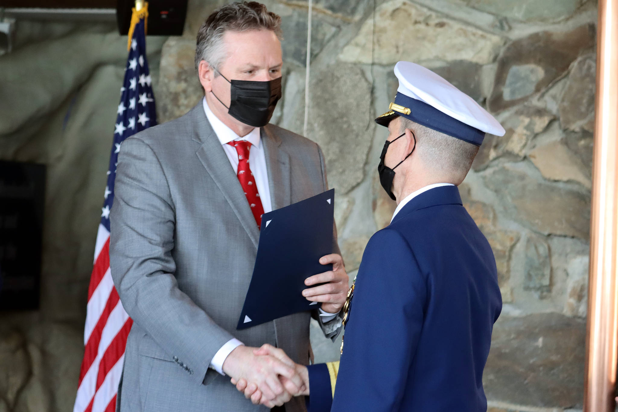 Gov. Mike Dunleavy shakes hands with Rear Adm. Matthew T. Bell Jr. during a Change of Command and retirement ceremony Friday, April 23, 2021 at Mendenhall Glacier Visitor Center. (Ben Hohenstatt / Juneau Empire)
