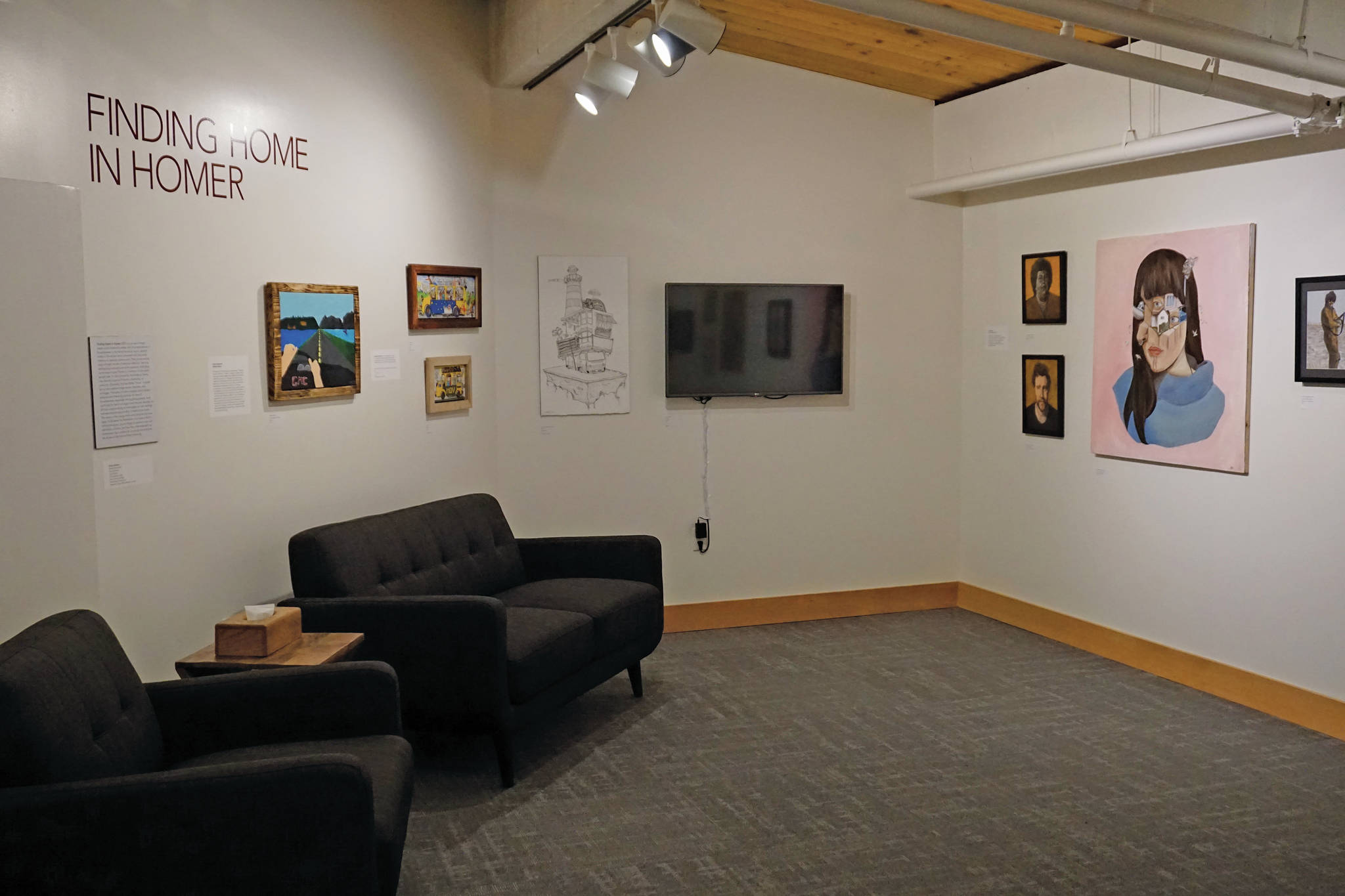The exhibit for “Finding Home in Homer” includes comfortable couches to sit and look at the art made by Alaska youth, as seen here on Tuesday, May 18, 2021, in Homer, Alaska. (Photo by Michael Armstrong/Homer News)