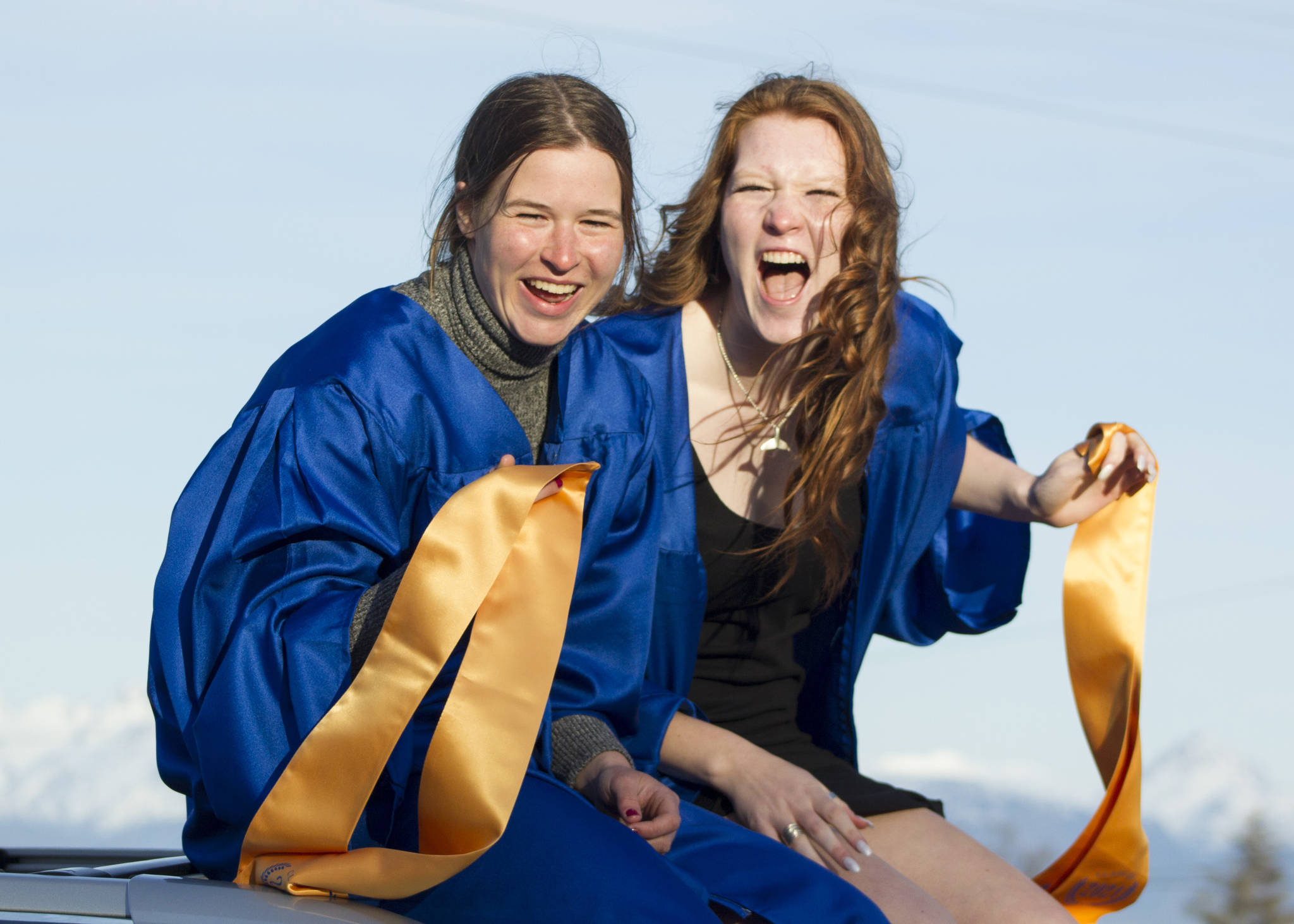 Two girls ride on top of their car during the graduation parade through Homer. (Photo by Sarah Knapp/Homer News)