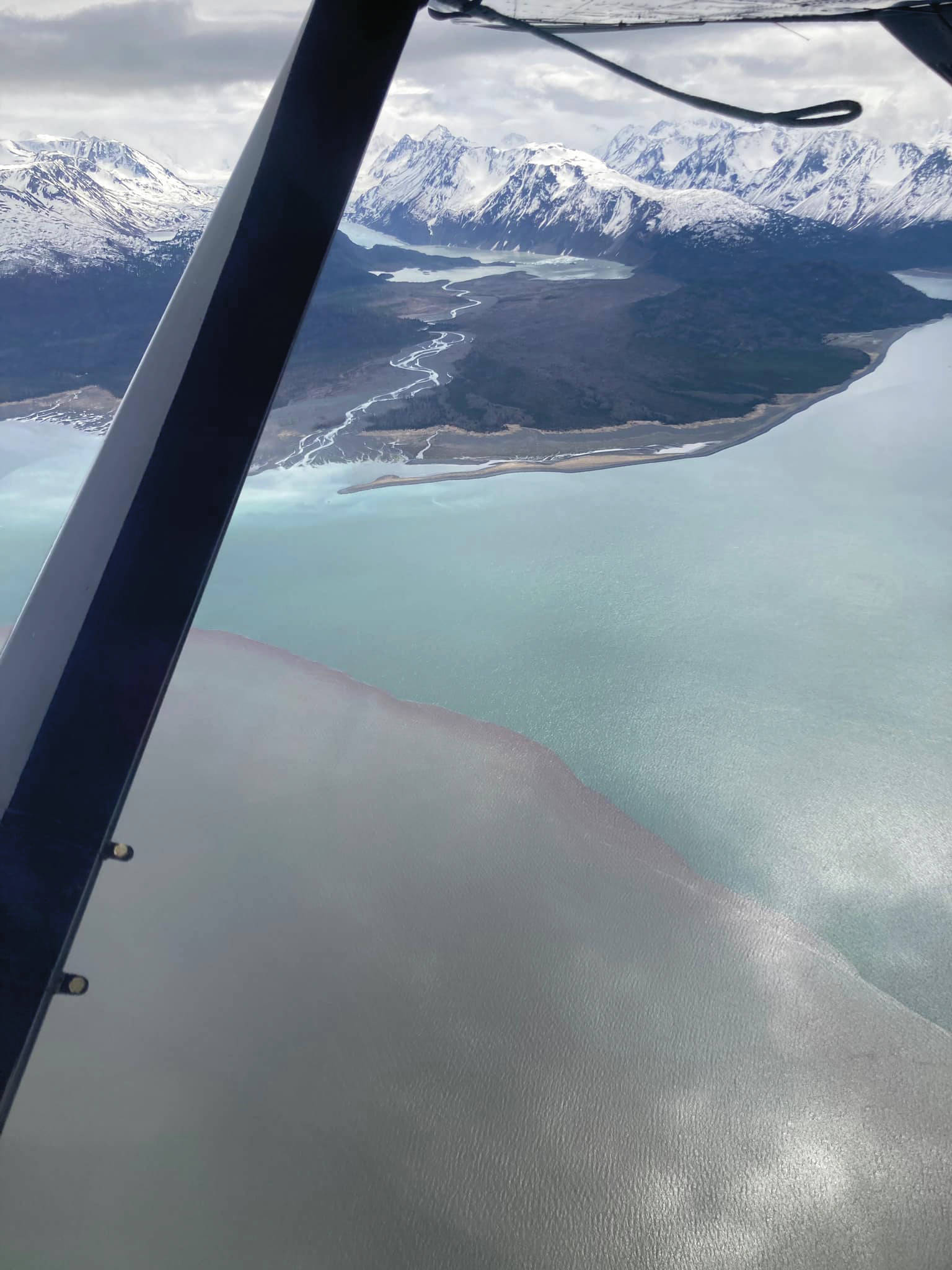 This photo taken by Beryl Air pilot Stephanie Greer on Friday, May 21, 2021, over Grewingk Glacier and Glacier Spit shows the mesodinium rubrum bloom to the left as contrasted with the normal ocean water of Kachemak Bay near Homer, Alaska. (Photo courtesy of Stephanie Greer/Beryl Air)