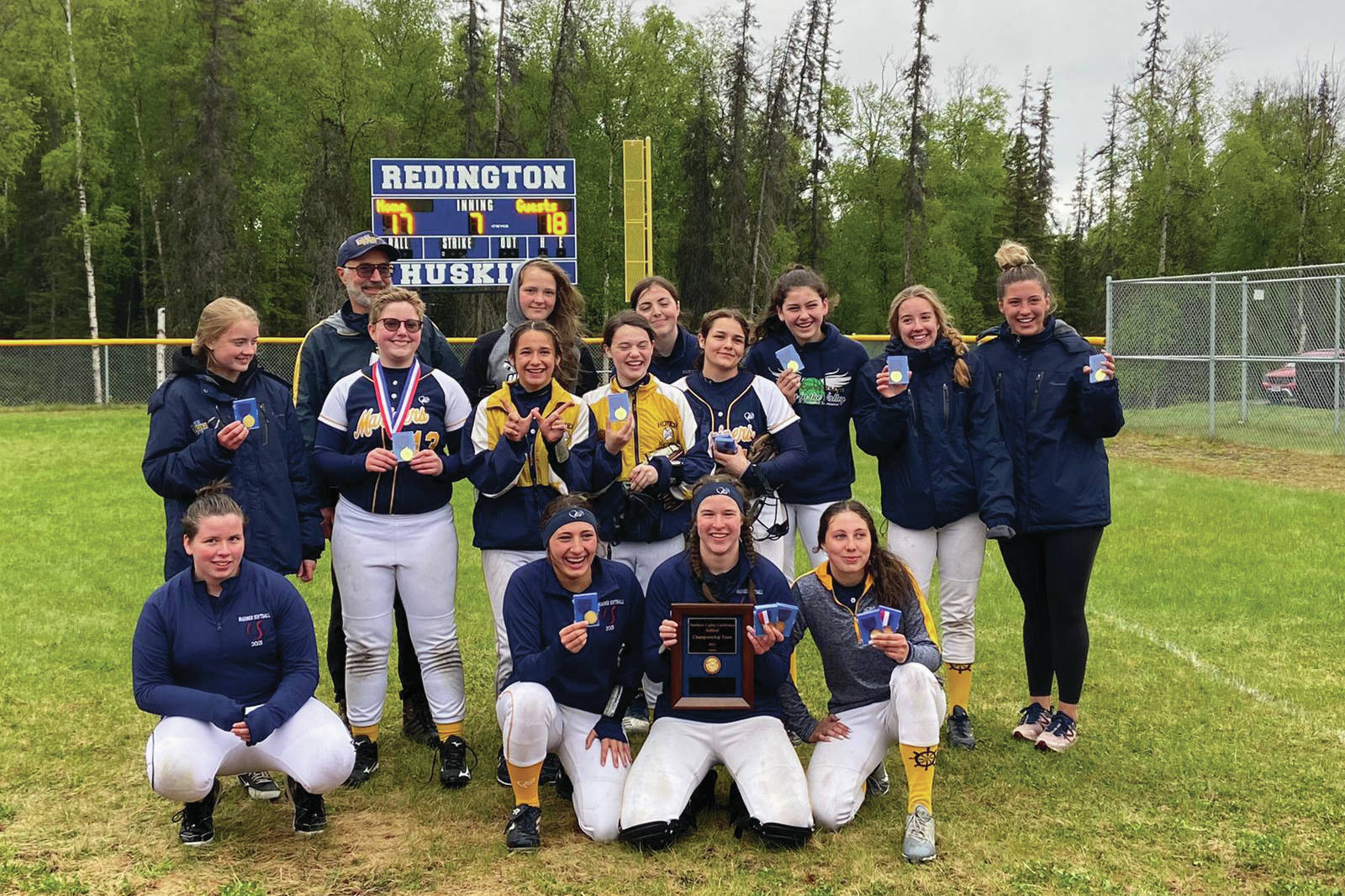 The Homer Mariner softball team celebrates after winning the Northern Lights Conference in an 18-17 win over Kodiak. At far left, back, is Coach Bill Bell, and at far right is Assistant coach Mary Hana Bowe. (Photo courtesy Homer Mariner Softball team)