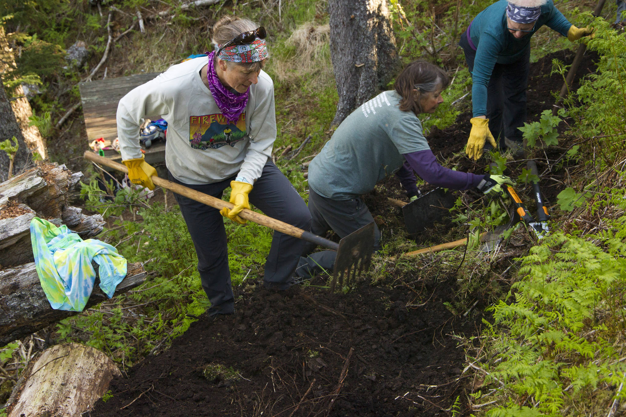 Kathy Sarns, Ruth Dickerson and Lyn Maslow work together to rebuild the trail tread at South Eldred Trail during National Trails Day. (Photo by Sarah Knapp/Homer News)