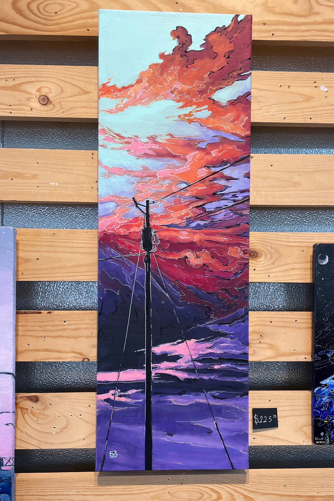 Reds and oranges spread across a sky painted by Jenna Gerrety, of Homer. Taking center stage, a power pole brings to mind “the push and pull of man and nature” that inspires the Homer artist. The painting and others by Gerrety are on display during June at Grace Ridge Brewing Company. (Photo by McKibben Jackinsky)