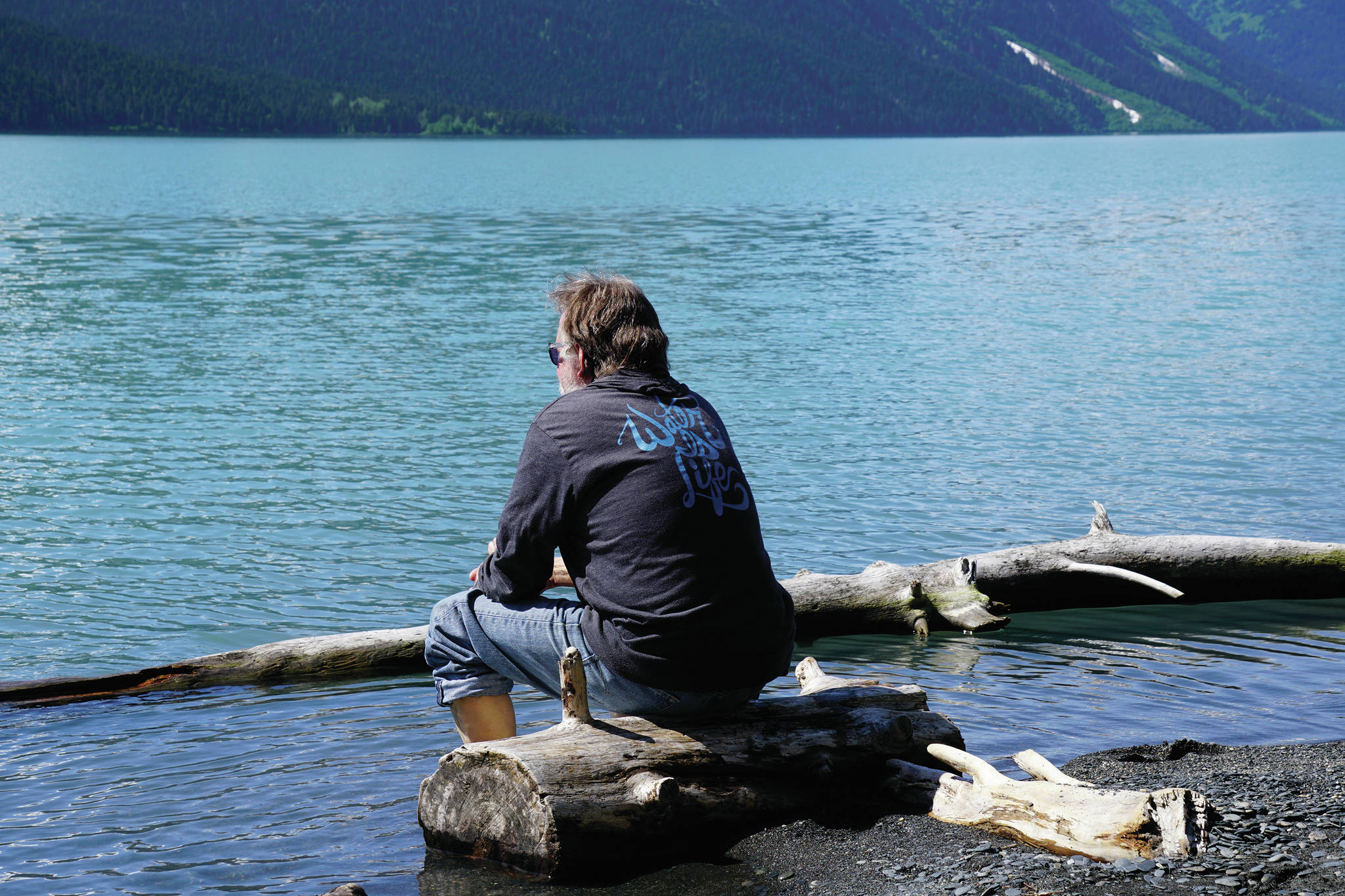 Homer News editor Michael Armstrong contemplates the icy waters of Kenai Lake on Saturday, June 12, 2021, at the Trail River Campground near Seward, Alaska. (Photo by Jennifer Stroyeck)