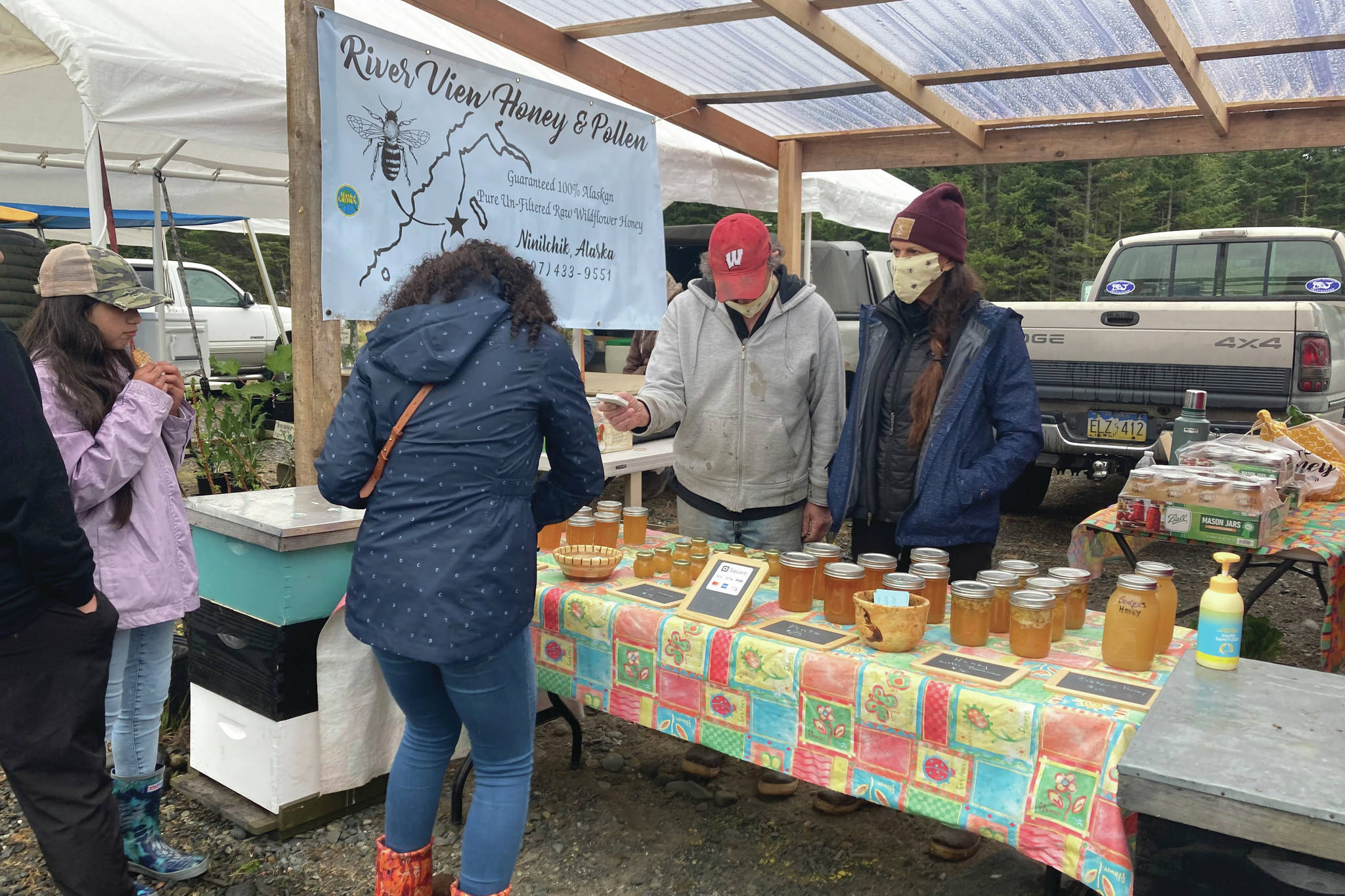 Photo by Sarah Knapp/Homer News
A woman purchases honey at the Homer Farmers Market on Saturday, May 29 in Homer.