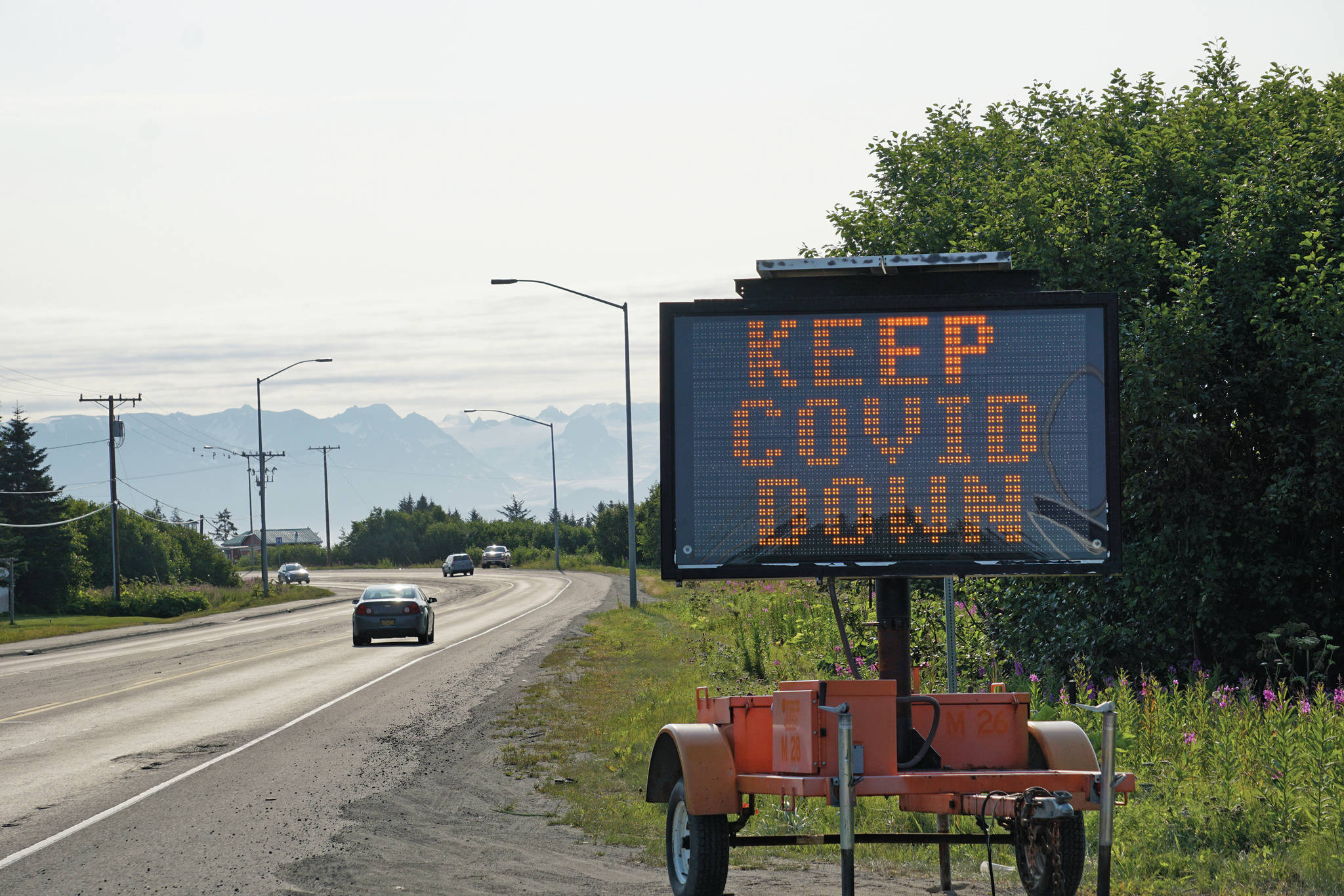 A portable sign on the Sterling Highway heading into Homer, Alaska, on Tuesday, Aug. 3, 2021, shows a COVID-19 safety alert. (Photo by Michael Armstrong/Homer News)