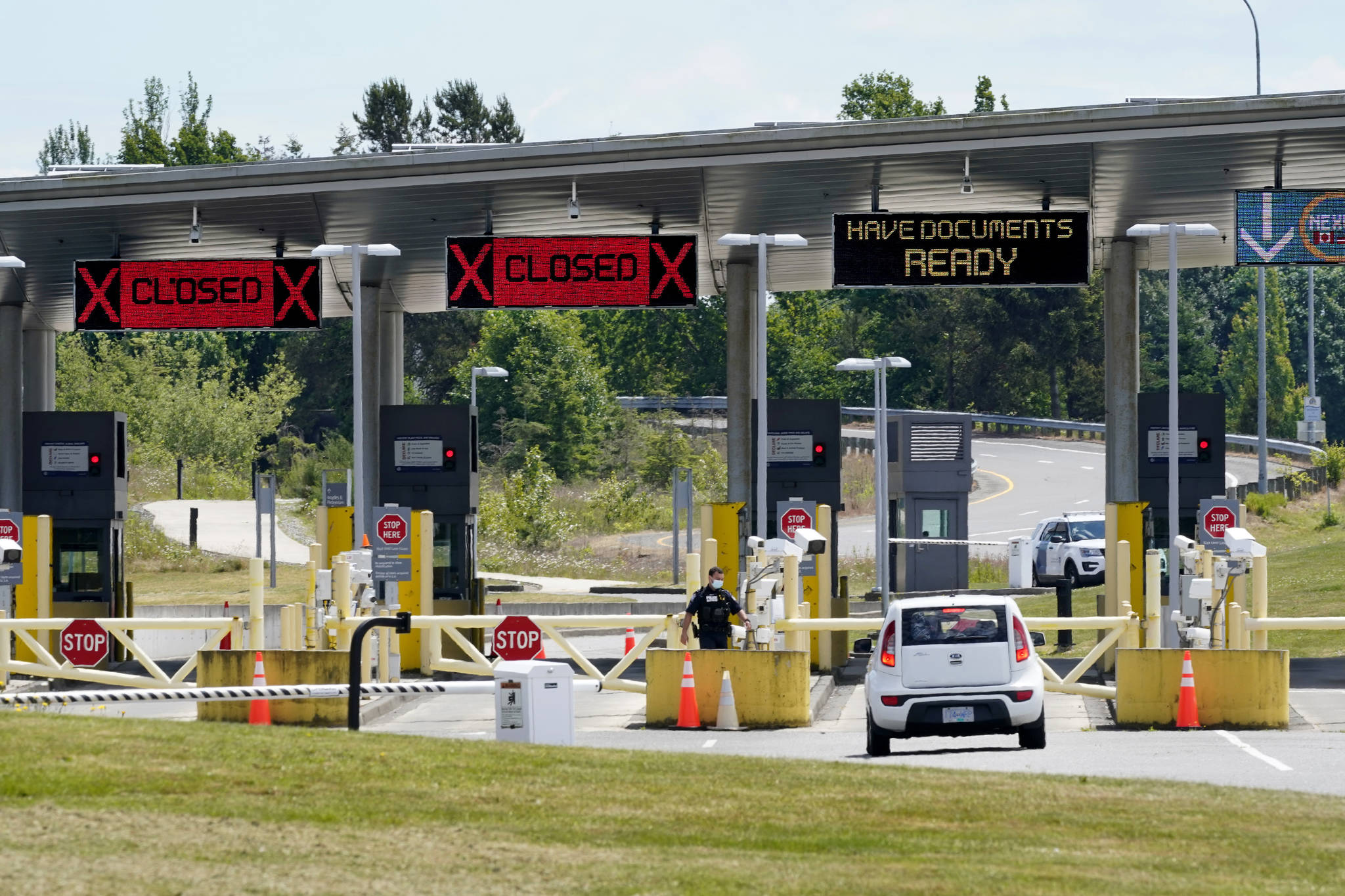 FILE - In this June 8, 2021, file photo, a car approaches one of the few lanes open at the Peace Arch border crossing into the U.S. in Blaine, Wash. Canada is lifting its prohibition Monday, Aug. 9 on Americans crossing the border to shop, vacation or visit, but the United States is keeping similar restrictions in place for Canadians. The reopening is part of a bumpy return to normalcy from COVID-19 travel bans.  (AP Photo/Elaine Thompson, File)