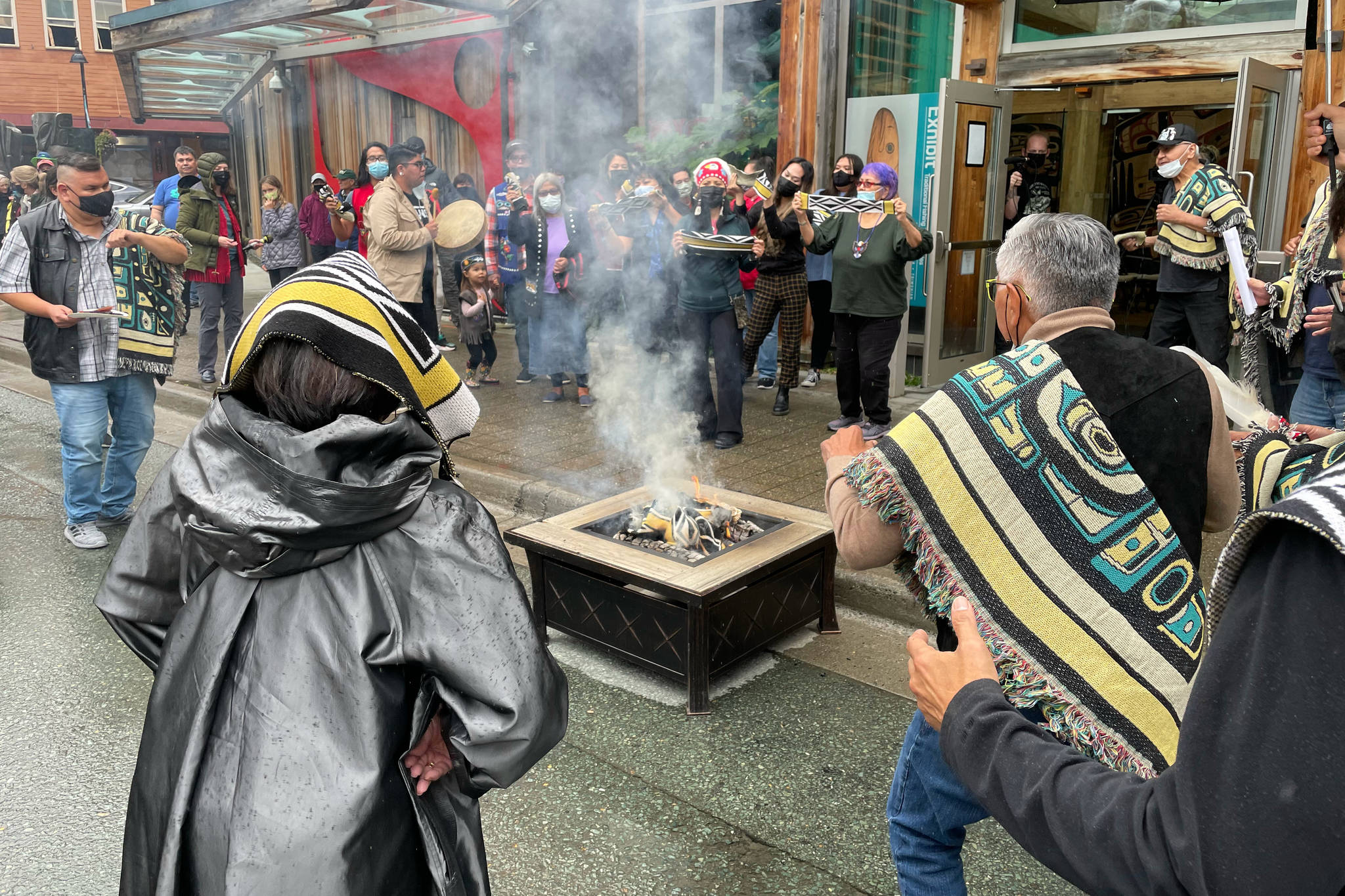 Participants burn an example of a commercial garment that led to a now-settled intellectual property lawsuit in a ceremony commemorating the settlement with the fashion company on Friday, Aug. 13, 2021. (Michael S. Lockett / Juneau Empire)