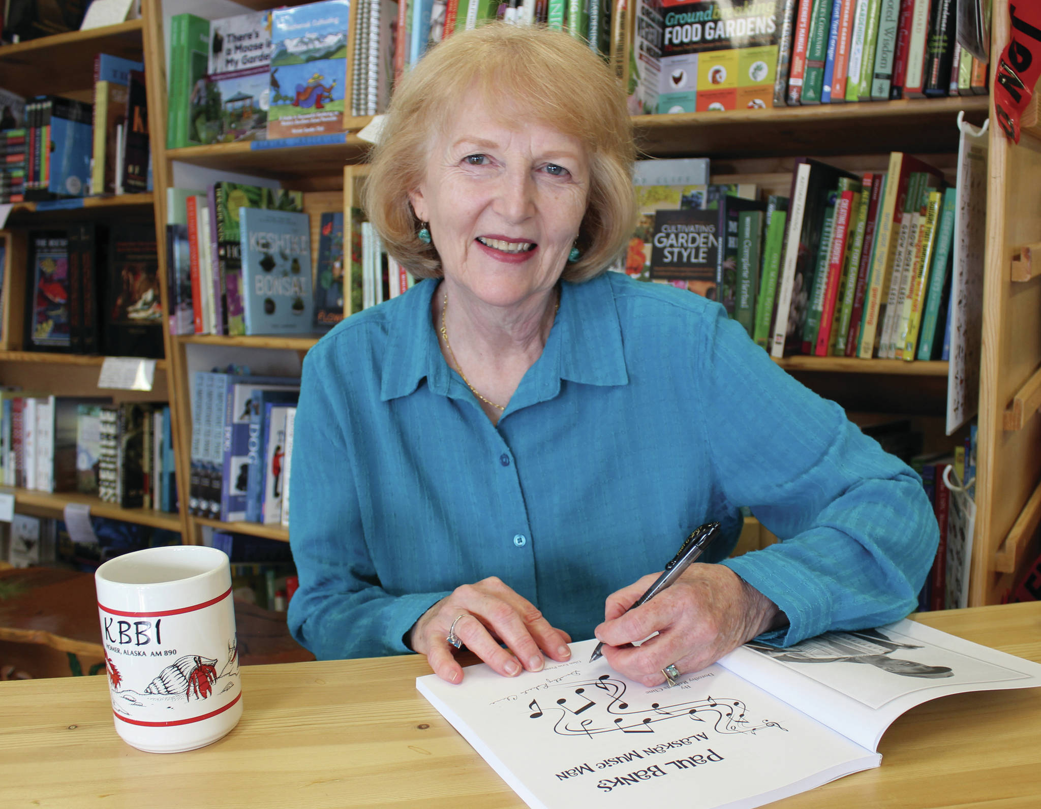 Author Dorothy “Dotty” Cline signs copies of “Paul Banks, Alaskan Music Man” at the Homer Bookstore on Sept. 27, 2014, in Homer, Alaska. (Photo by McKibben Jackinsky / Homer News file photo)
