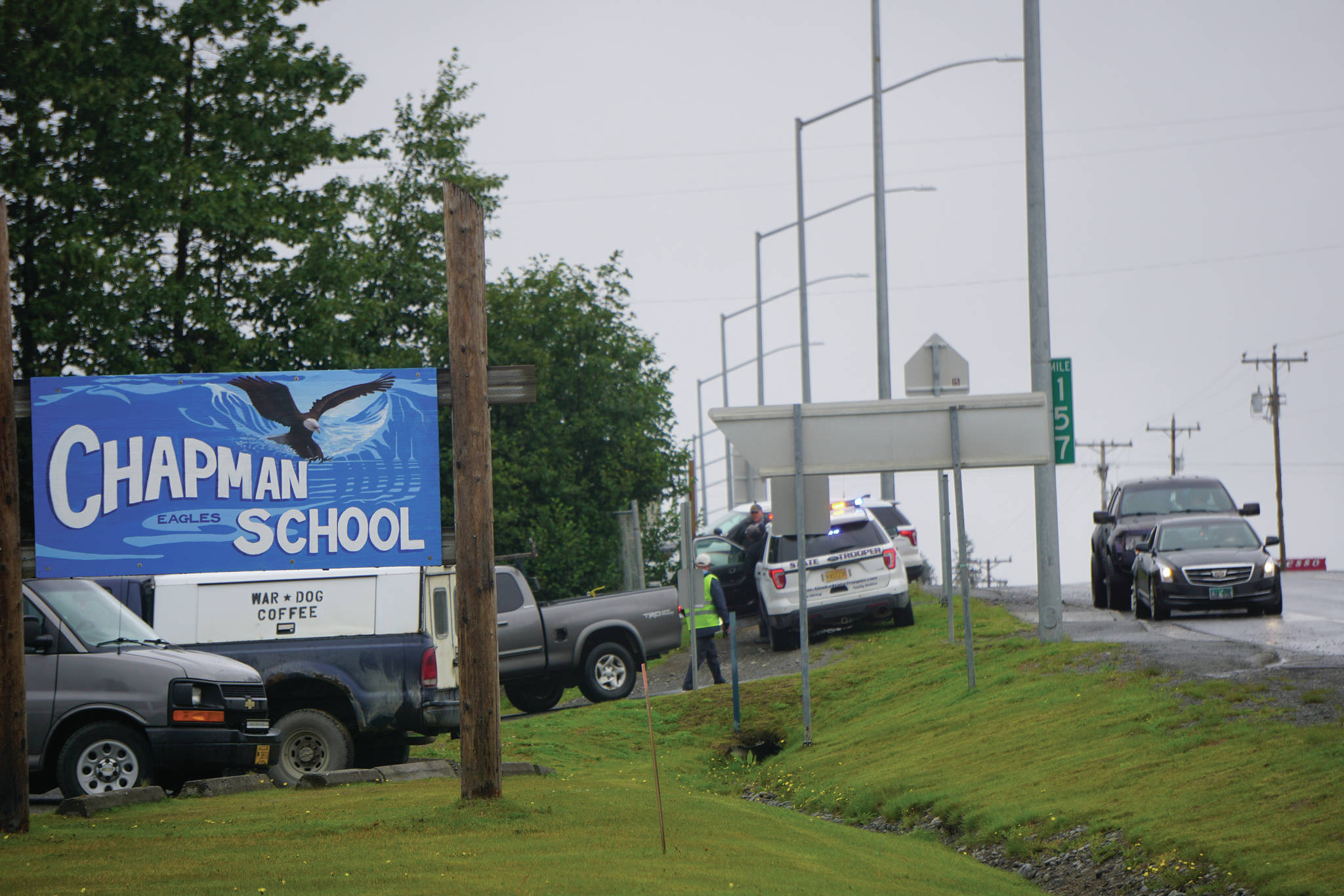 Photo by Michael Armstrong/Homer News 
Parents on Monday, Aug. 23, 2021, pick up students at Chapman School in Anchor Point, Alaska, after a shooting about a half mile north on the Sterling Highway in which an Alaska State Trooper was shot. The school was on lockdown while troopers searched for the alleged shooter, Bret Herrick, 60. An Alaska State Trooper stands by.