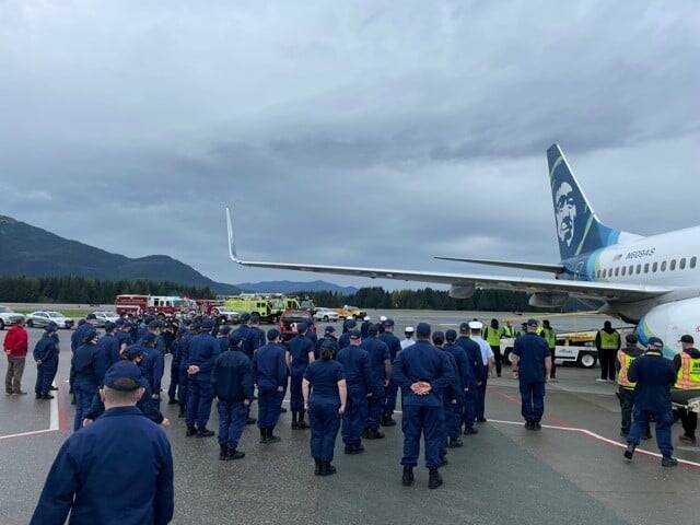 Coast Guardsmen stand in formation at Juneau International Airport as the body of Chief Petty Officer Jeffery DeRonde, who died over the weekend, is loaded on an airplane on Sept. 7, 2021. (Courtesy photo / Capital City Fire/Rescue)