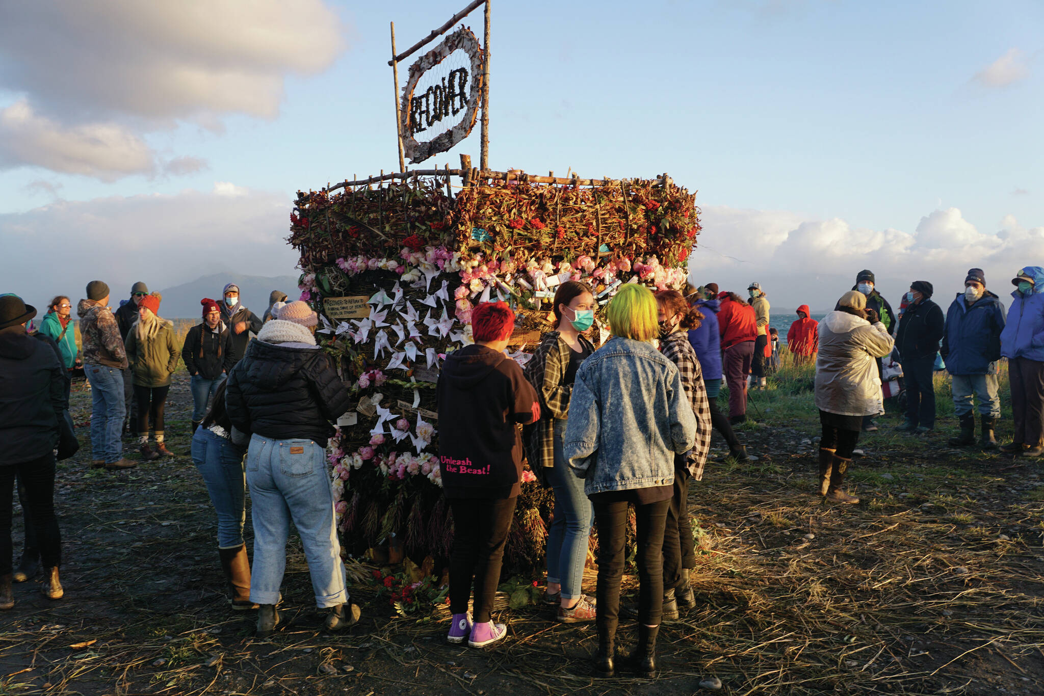 People interact with Recover, the 18th annual Burning Basket, before it’s ignited on Sunday, Sept. 12, 2021, at Mariner Park on the Homer Spit in Homer, Alaska. (Photo by Michael Armstrong/Homer News)