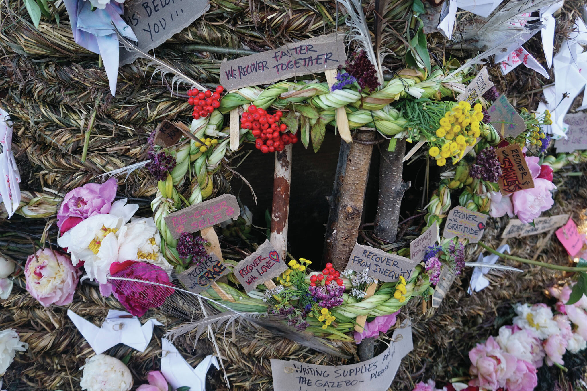 Signs, flowers and origami cranes decorate Recover, the 18th annual Burning Basket, on Sunday, Sept. 12, 2021, at Mariner Park on the Homer Spit in Homer, Alaska. (Photo by Michael Armstrong/Homer News)