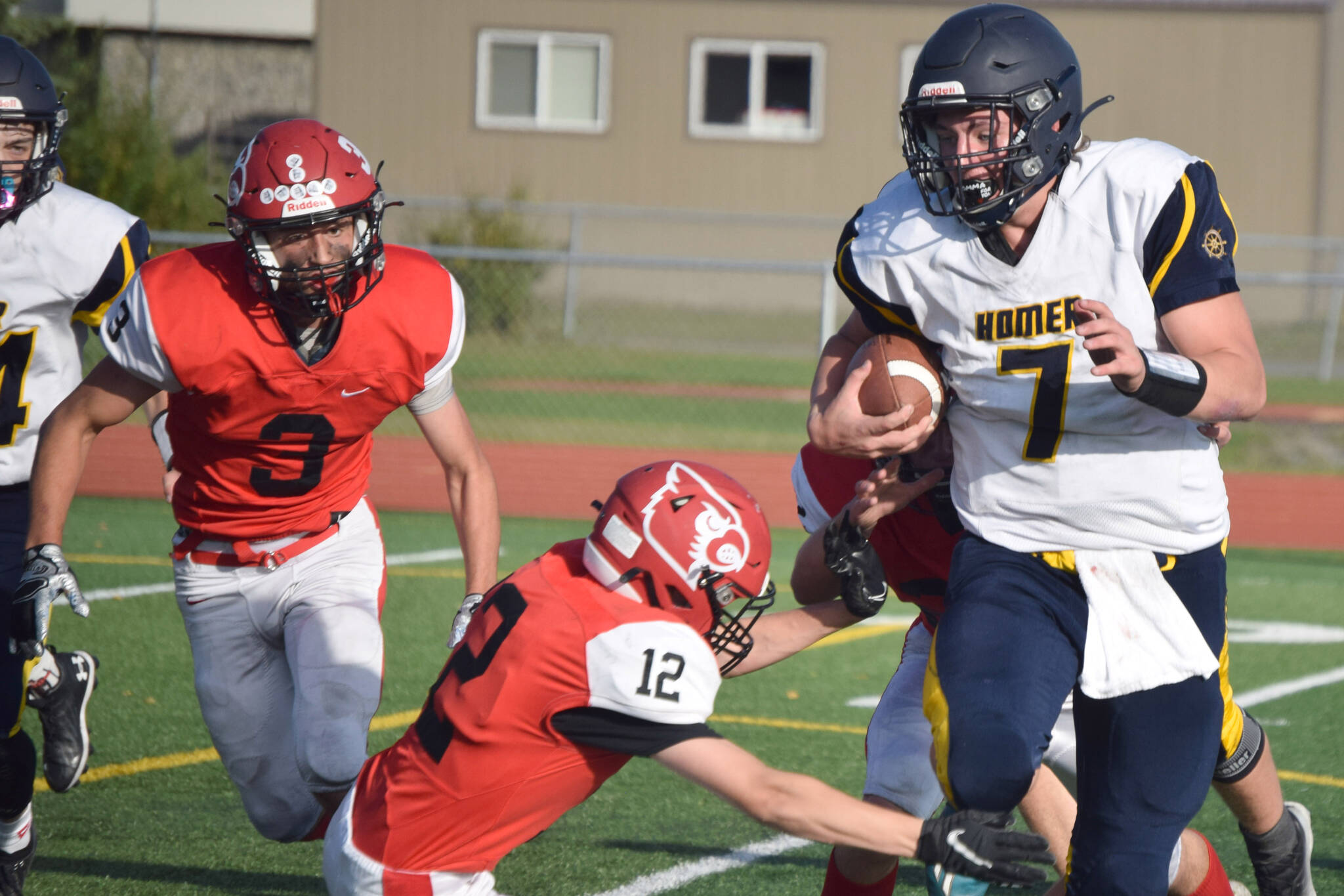 Homer quarterback Carter Tennison tries to avoid the tackle of Kenai Central’s Talon Whicker on Friday, Sept. 17, 2021, at Ed Hollier Field in Kenai, Alaska. (Photo by Jeff Helminiak/Peninsula Clarion)