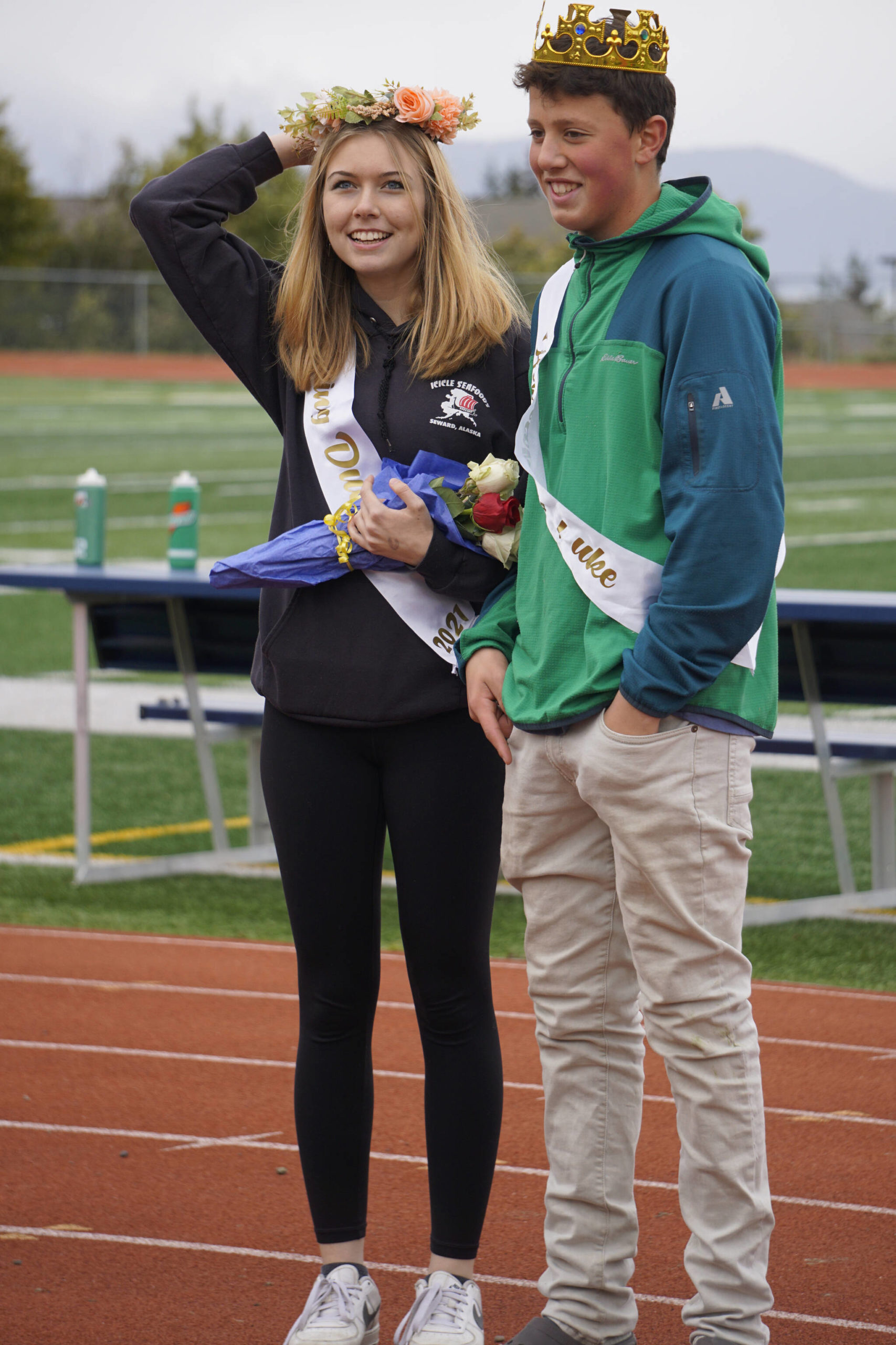 Sophomore class Duchess Minadora Reutov adjusts her crown as Duke Camden Wise watches at the Homer vs. Nikiski junior varsity football game on Saturday, Oct. 2, 2021, at Homer High School. (Photo by Michael Armstrong/Homer News)