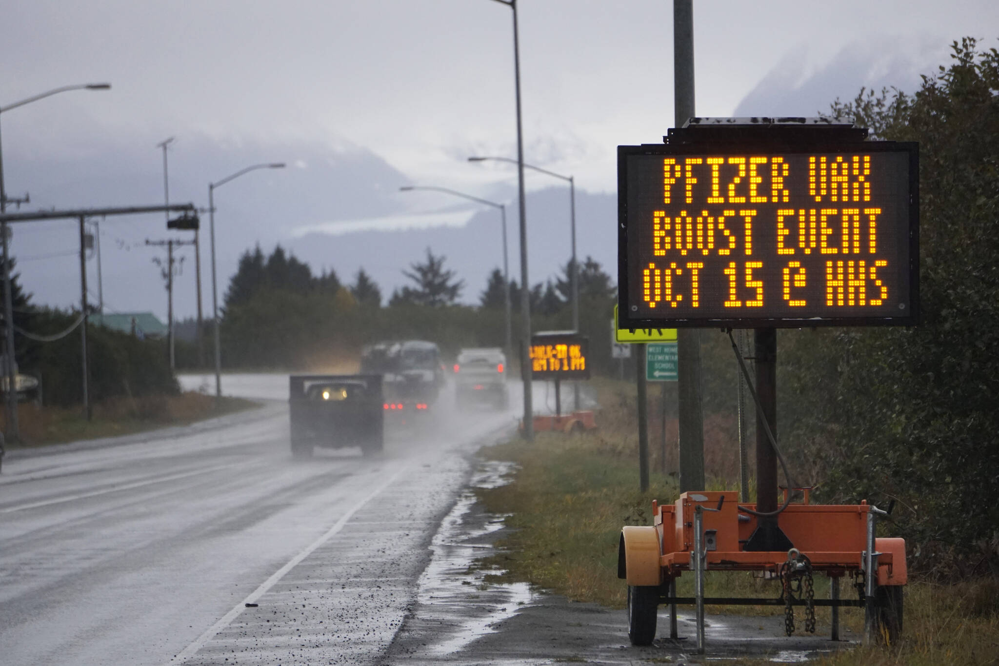 A portable sign on the Sterling Highway advertises a Pfizer COVID-19 vaccinaton booster clinic to be held 9 a.m. to 1 p.m. Friday, Oct. 15, 2021, at Homer High School in Homer, Alaska. A flu clinic also will be held at the same time at the high school. Appointments are encouraged for the Pfizer clinic. Visit www.sphosp.org for information. (Photo by Michael Armstrong/Homer News)