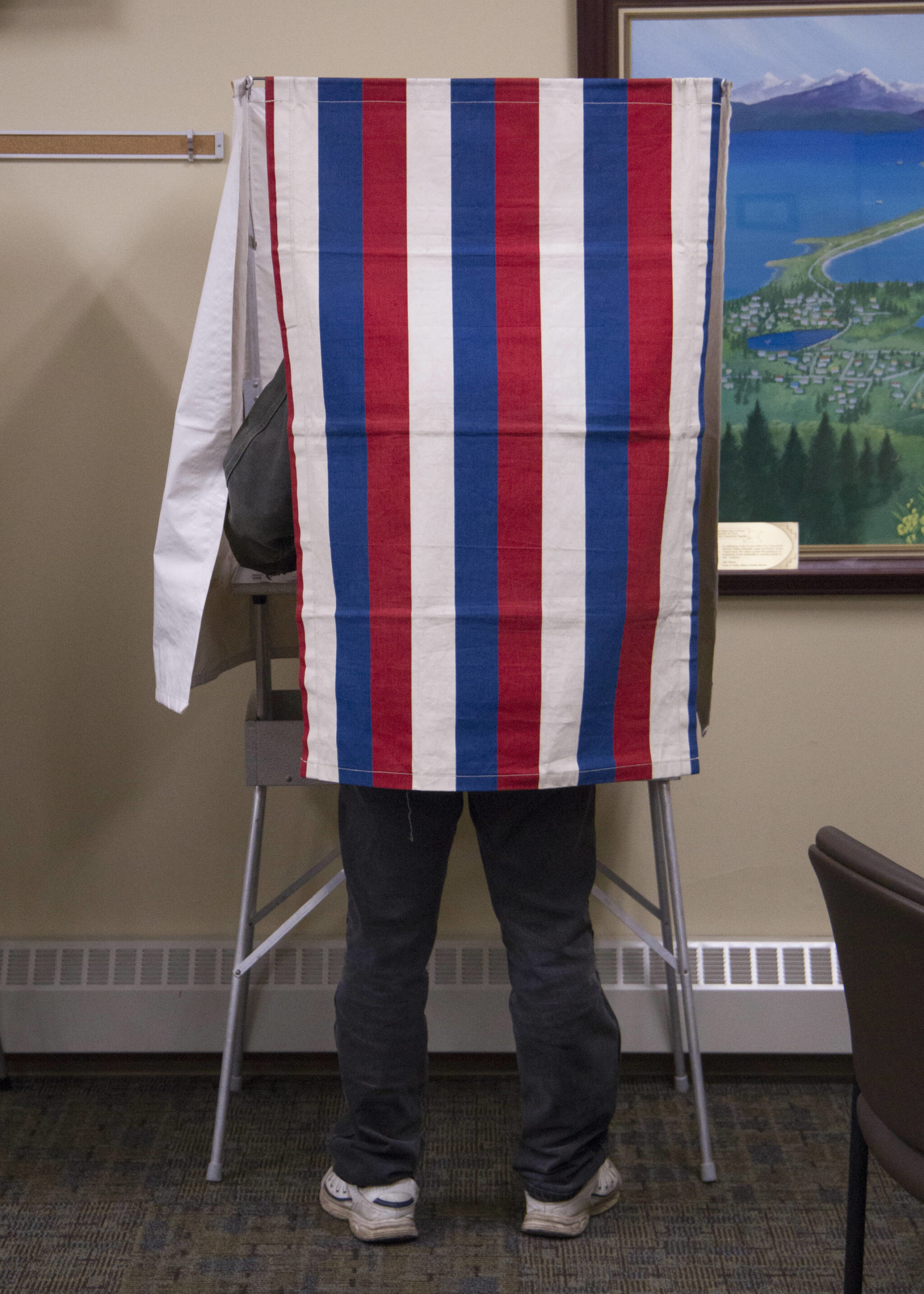 A voter uses the privacy curtain to cast his ballot at the Homer City Hall on Oct. 5. (Photo by Sarah Knapp/Homer News)